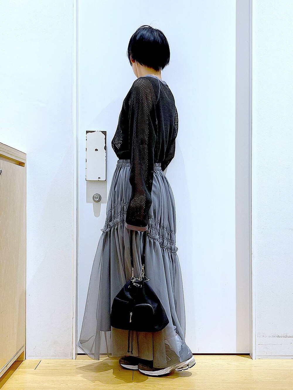 ブラック系のTシャツ/カットソー、グレー系のスカートを着用したレディースの春コーディネートの3枚目の写真