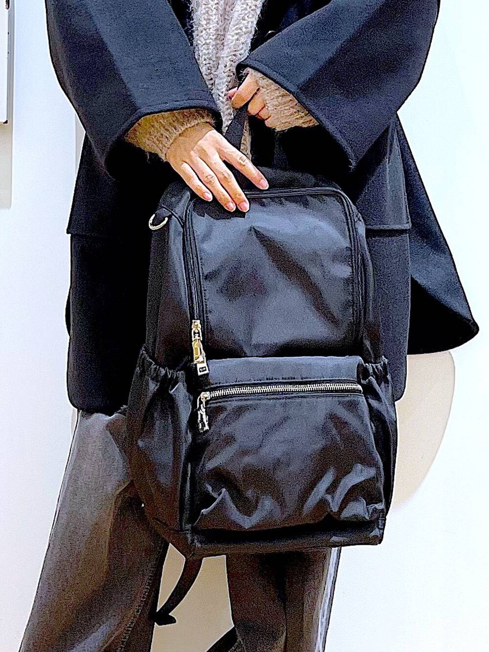 ブラック系のバックパック/リュック、ブラック系のその他アウター、ベージュ系のスニーカーを着用したレディースの冬コーディネートの9枚目の写真