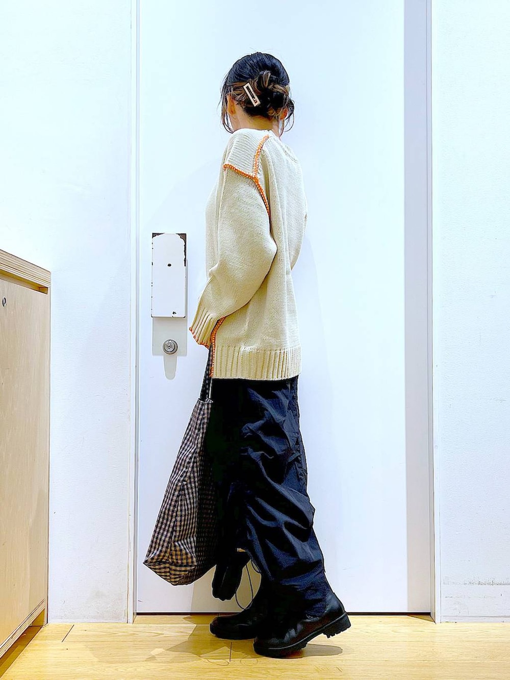 ブラック系のブーツ、その他のトートバッグ、ブラック系のスカートを着用したレディースの冬コーディネートの3枚目の写真