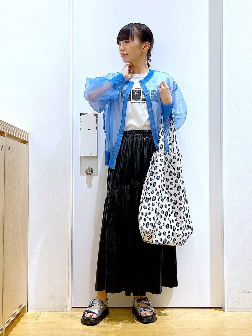 シルバー系のサンダル、ブルー系のカーディガン/ボレロ、ホワイト系のトートバッグを着用したレディースの夏コーディネートの2枚目の写真