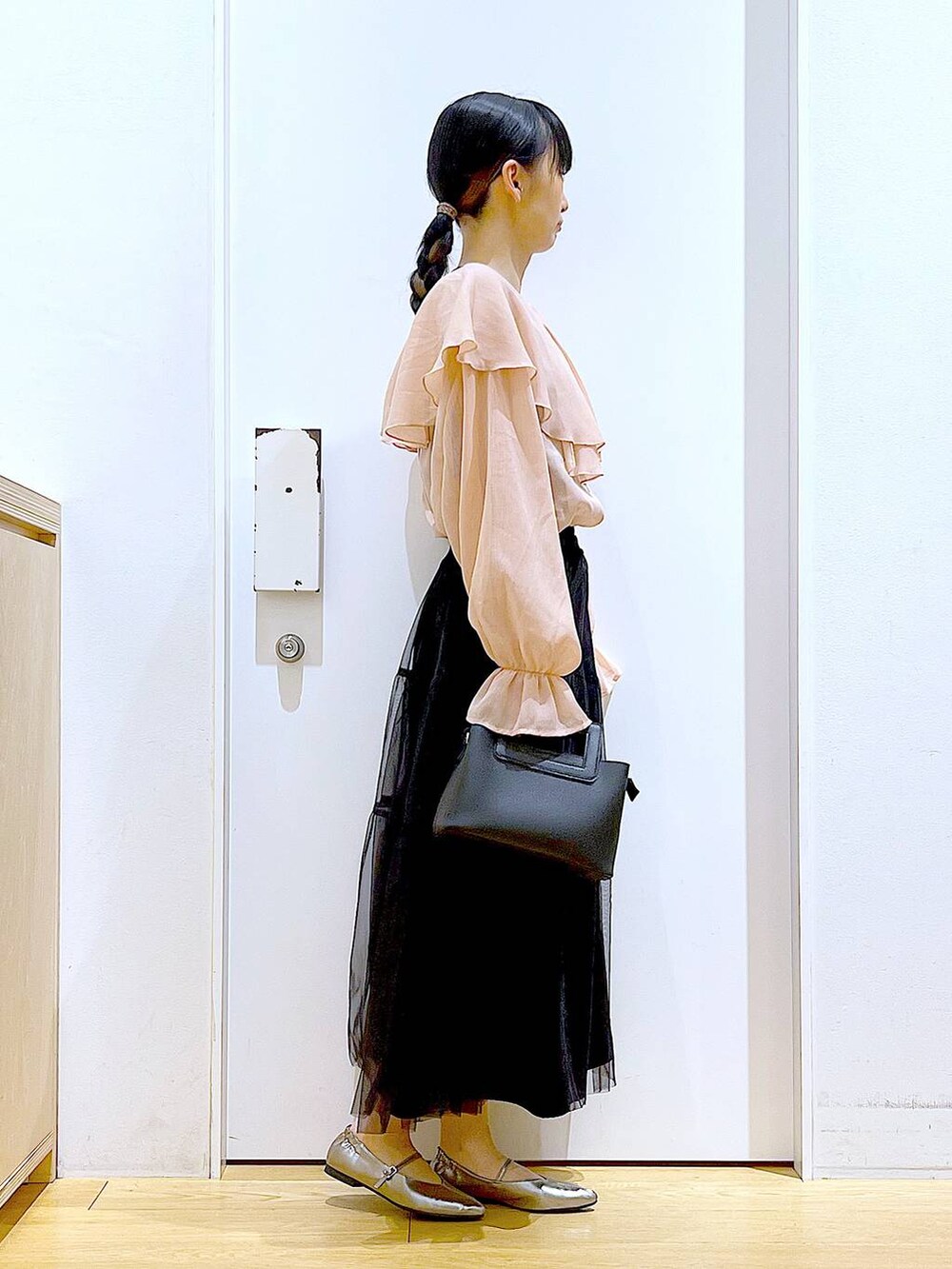 ブラック系のスカート、ブラック系のショルダーバッグ、その他のパンプスを着用したレディースの春コーディネートの4枚目の写真