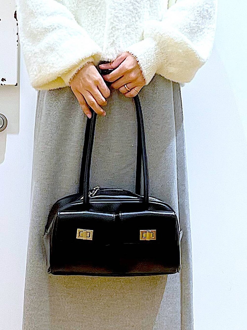 ブラック系のハンドバッグ、ブラック系のブーツ、グレー系のスカートを着用したレディースの冬コーディネートの9枚目の写真