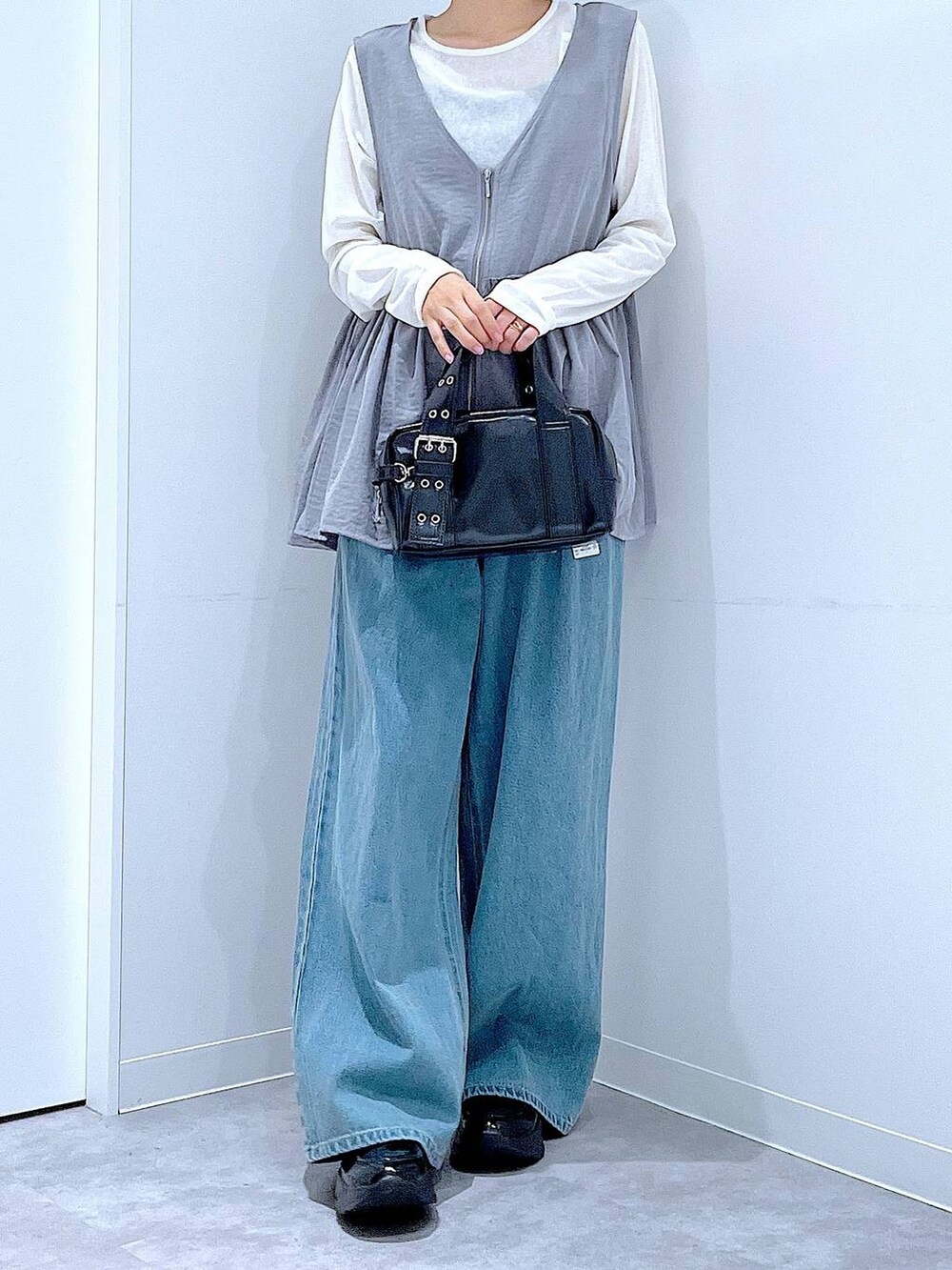 ホワイト系のTシャツ/カットソー、ブラック系のローファー、ブラック系のショルダーバッグを着用したレディースの秋コーディネートの6枚目の写真