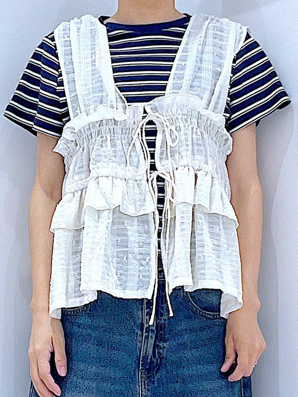 ブルー系のデニムパンツ、イエロー系のショルダーバッグ、ブラック系のスニーカーを着用したレディースの春コーディネートの7枚目の写真