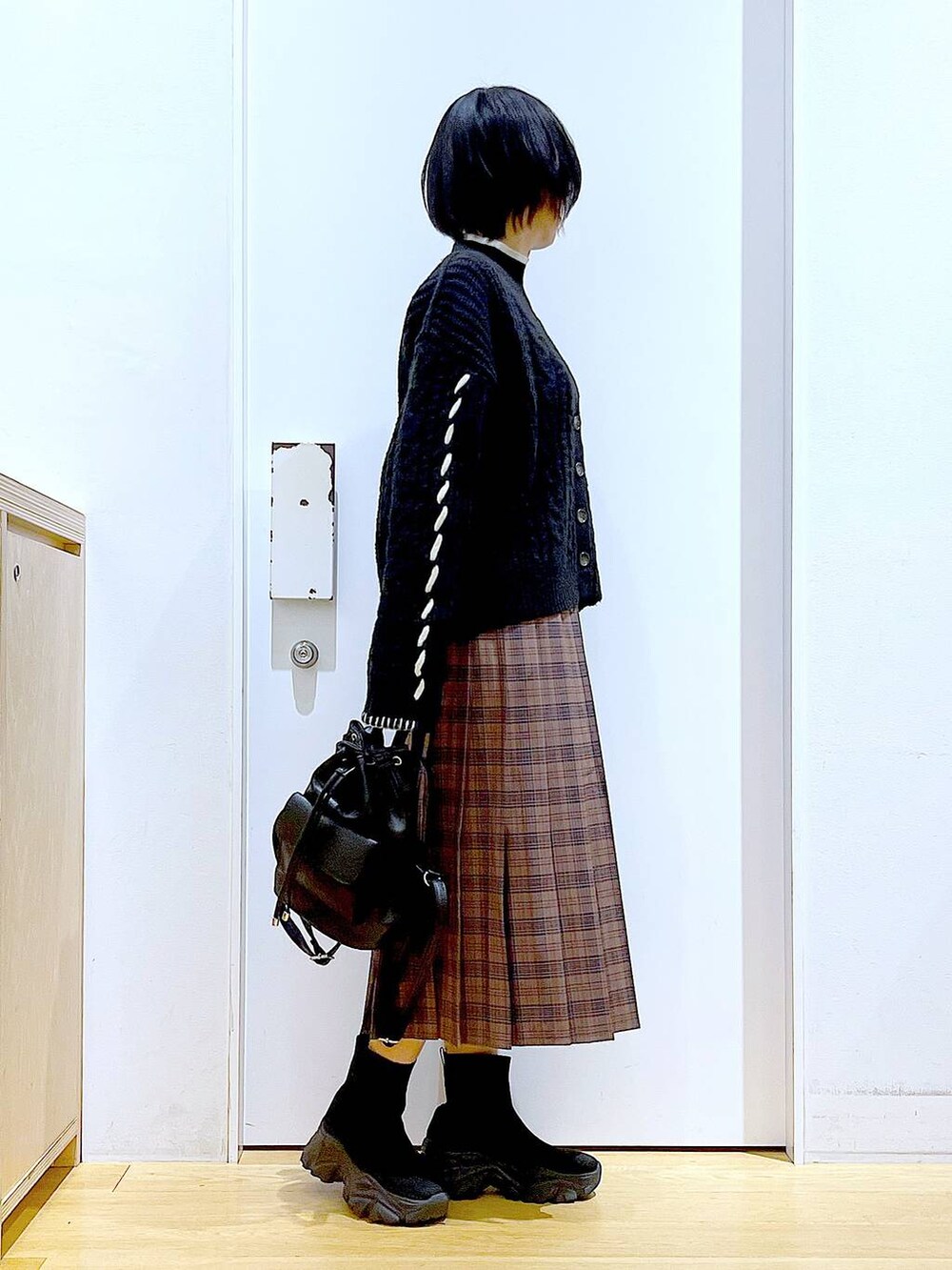 ブラック系のニット/セーター、ブラック系のバックパック/リュック、ブラック系のブーツを着用したレディースの冬コーディネートの4枚目の写真