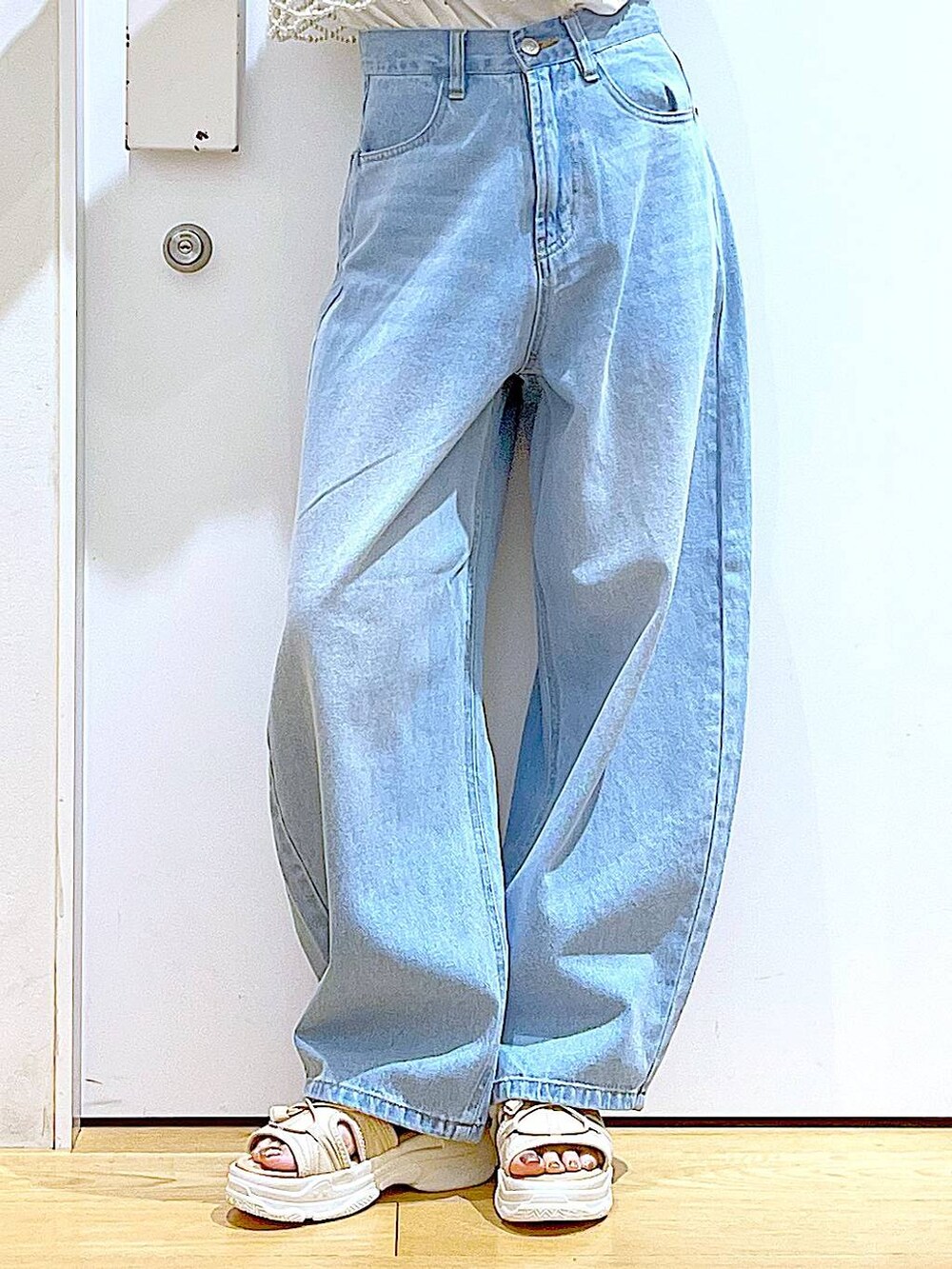 シルバー系のショルダーバッグ、ベージュ系のサンダル、ブルー系のデニムパンツを着用したレディースの夏コーディネートの8枚目の写真