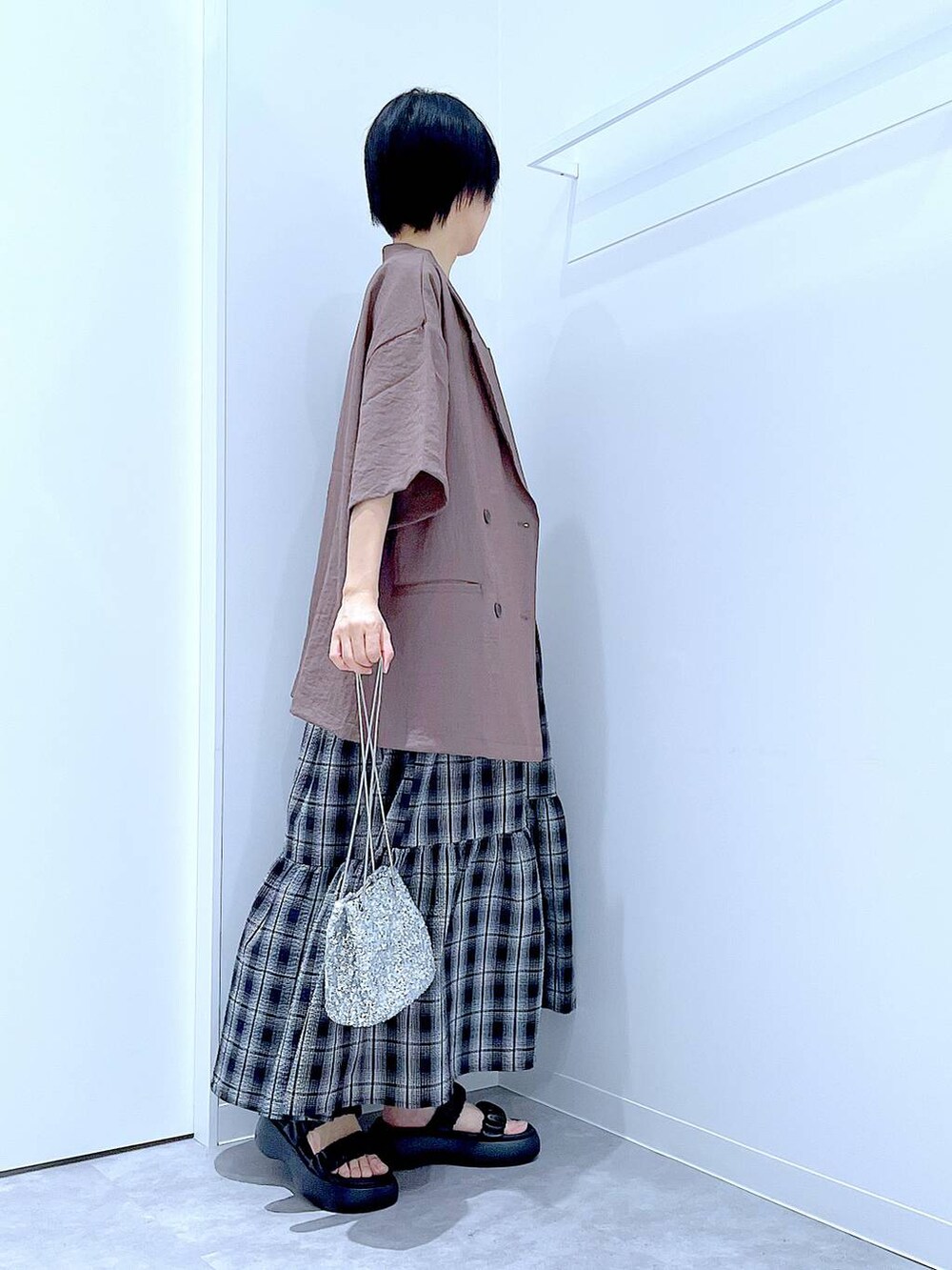 ブラック系のサンダル、シルバー系のショルダーバッグ、ブラウン系のテーラードジャケットを着用したレディースの夏コーディネートの4枚目の写真