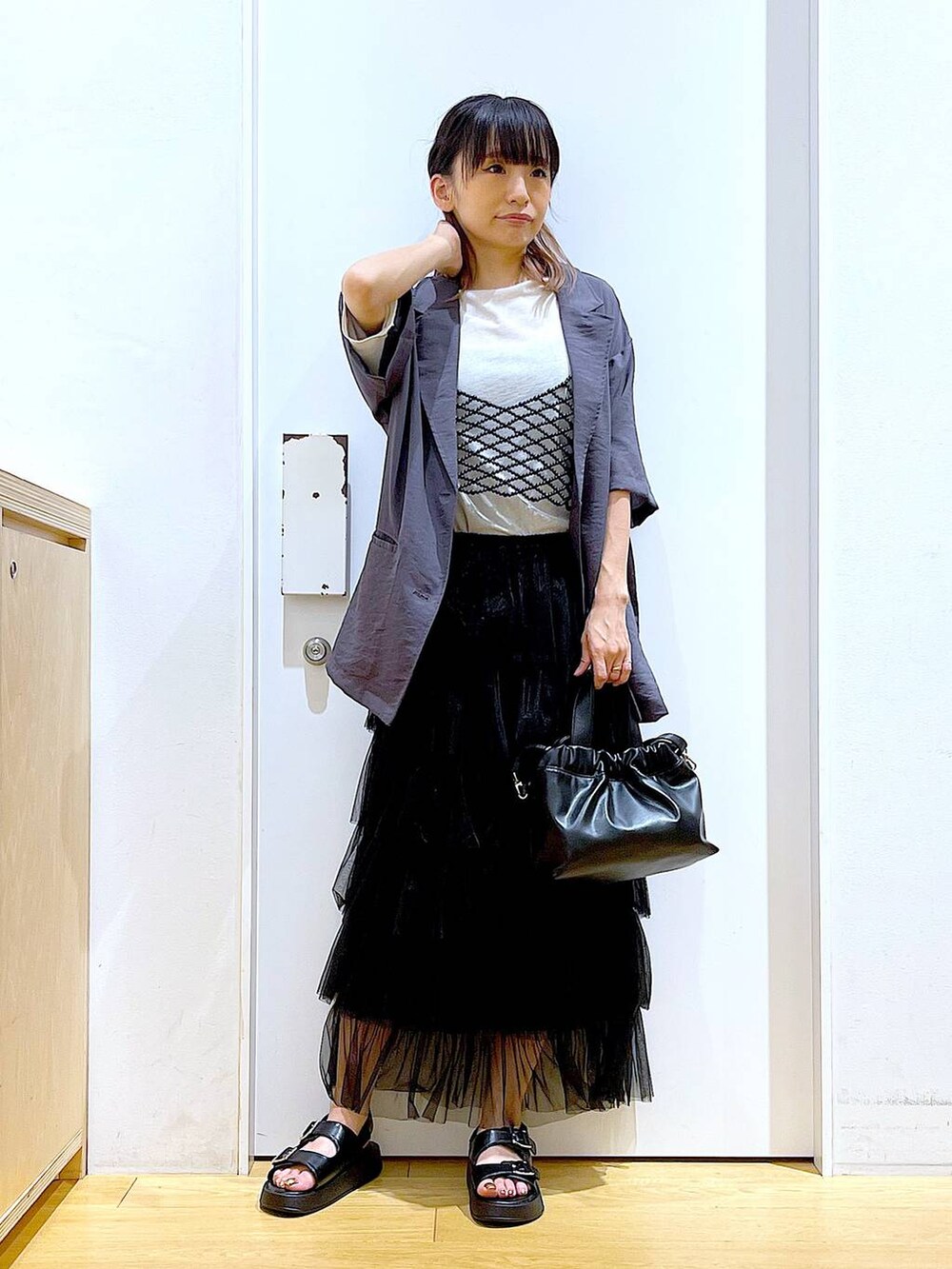 ブラック系のサンダル、ブラック系のショルダーバッグ、ブラック系のスカートを着用したレディースの夏コーディネートの2枚目の写真