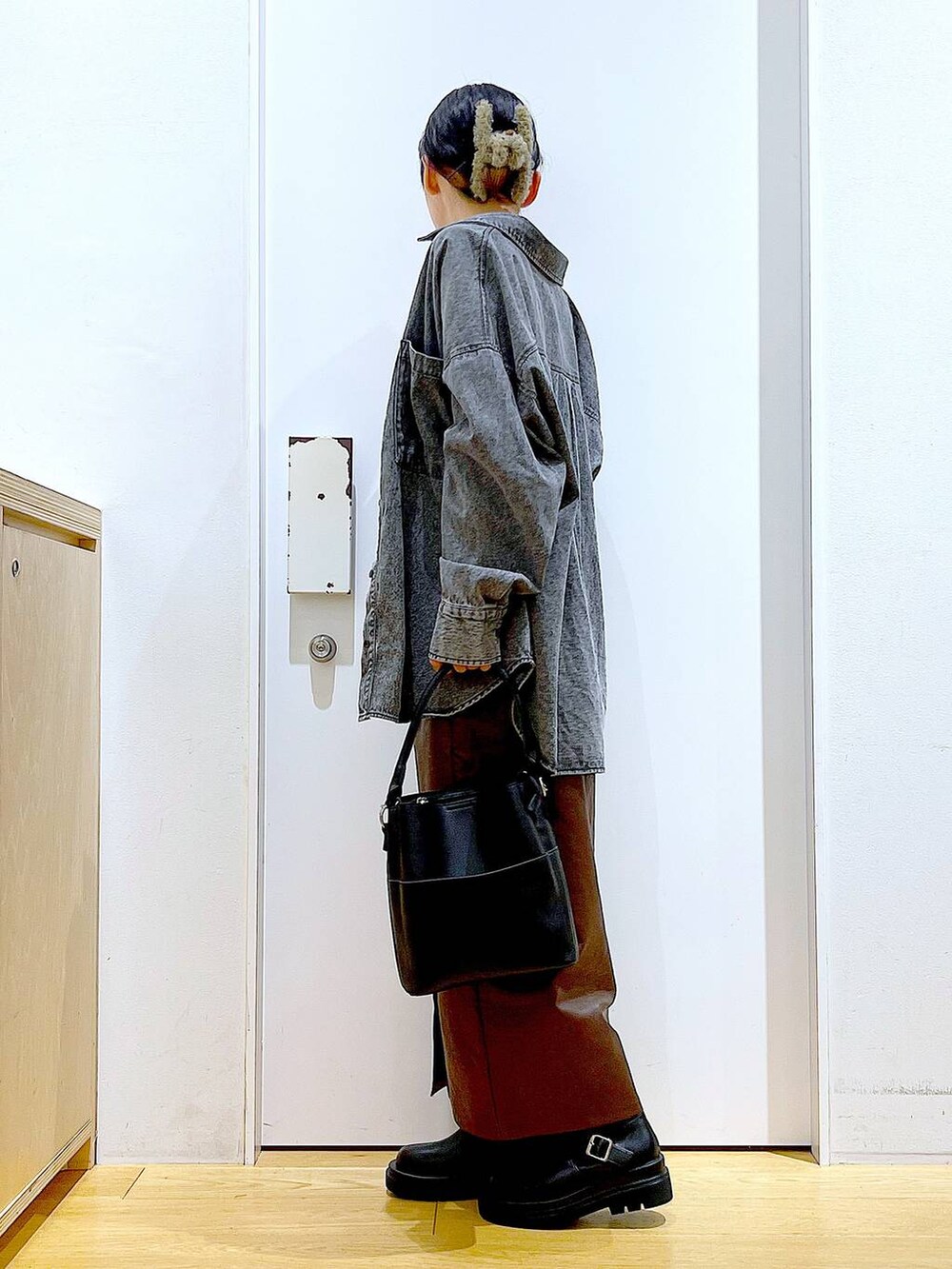 ブラウン系のスカート、ブラック系のニット/セーター、ブラック系のショルダーバッグを着用したレディースの秋コーディネートの3枚目の写真