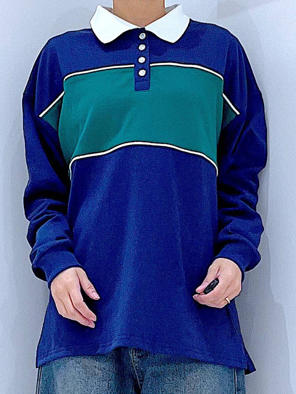 ブルー系のデニムパンツ、ホワイト系のショルダーバッグ、ブルー系のポロシャツを着用したレディースの冬コーディネートの7枚目の写真