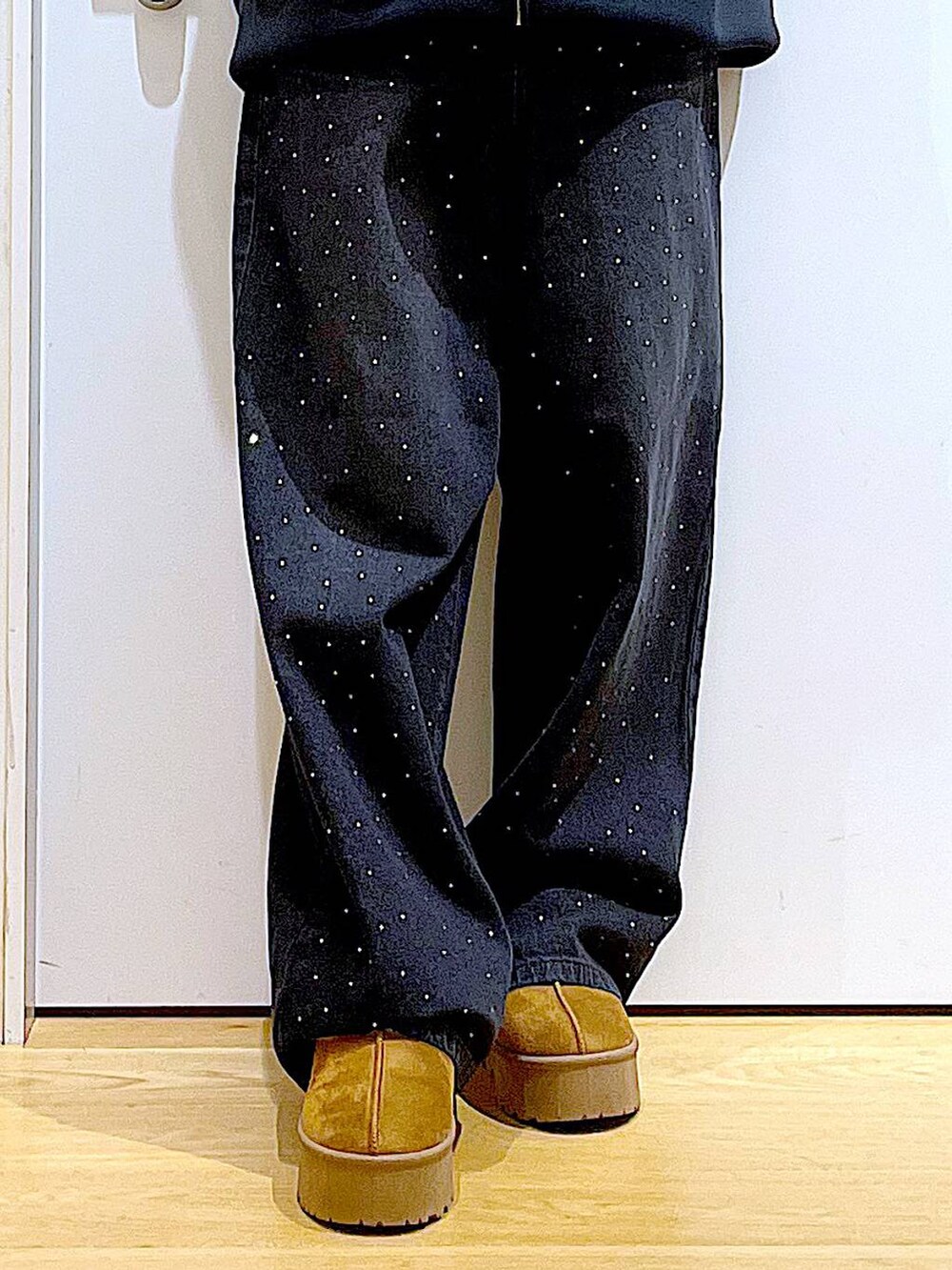 ベージュ系のスリッポン、ベージュ系のショルダーバッグ、ブラック系のデニムパンツを着用したレディースの冬コーディネートの8枚目の写真