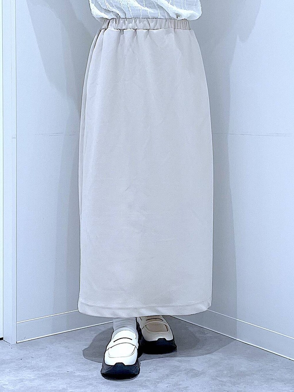 ベージュ系のスカート、ホワイト系のローファー、その他のショルダーバッグを着用したレディースの秋コーディネートの8枚目の写真