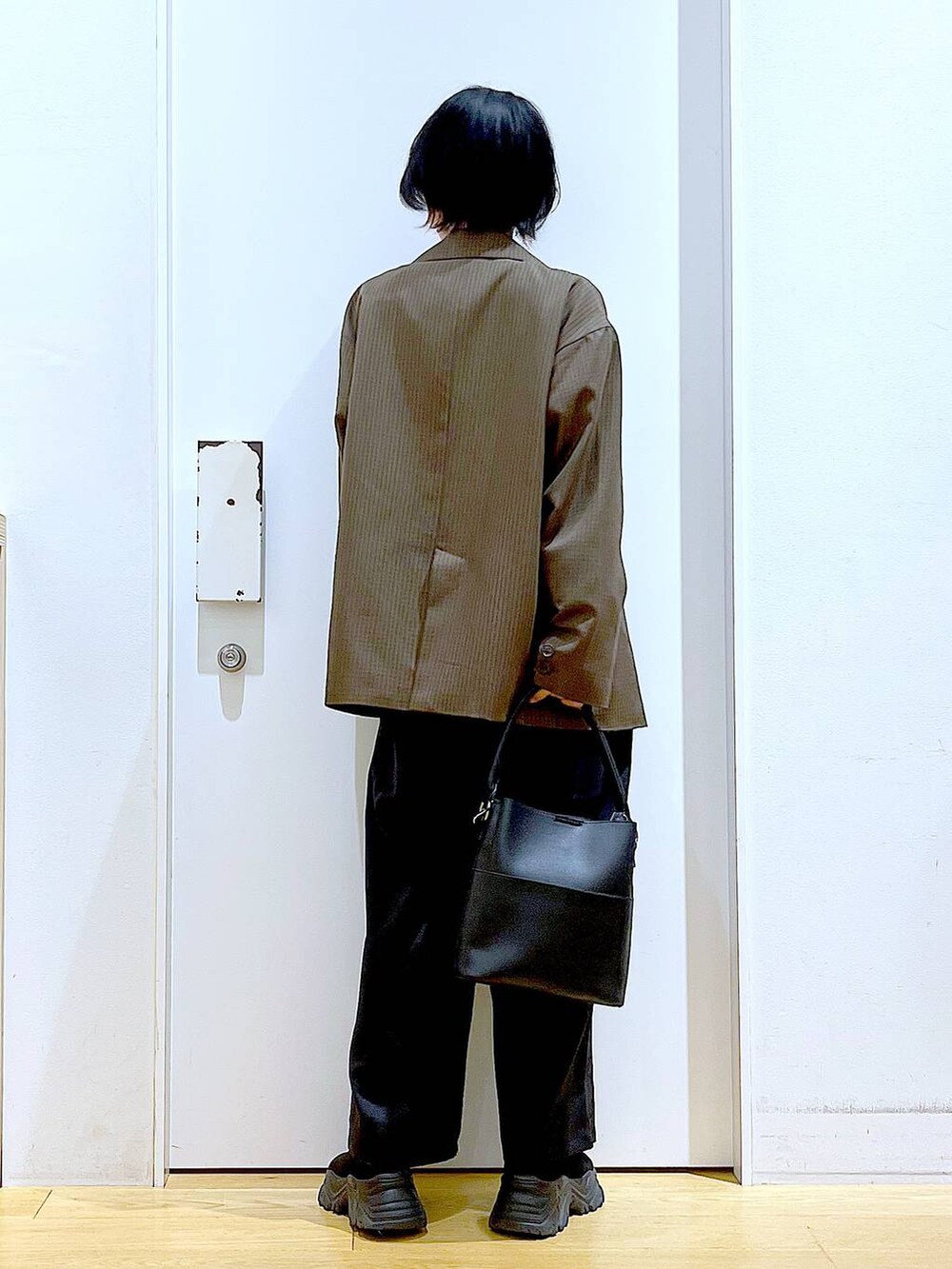 ブラック系のブーツ、ブラック系のショルダーバッグ、ブラウン系のテーラードジャケットを着用したレディースの秋コーディネートの5枚目の写真