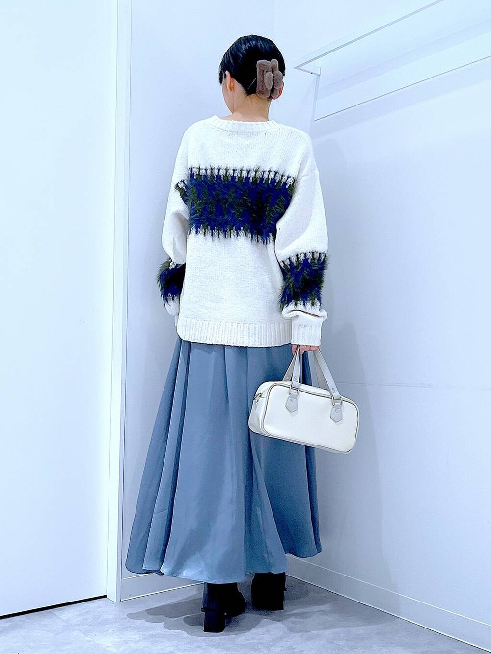 ブラック系のブーツ、ホワイト系のショルダーバッグ、ホワイト系のニット/セーターを着用したレディースの冬コーディネートの5枚目の写真