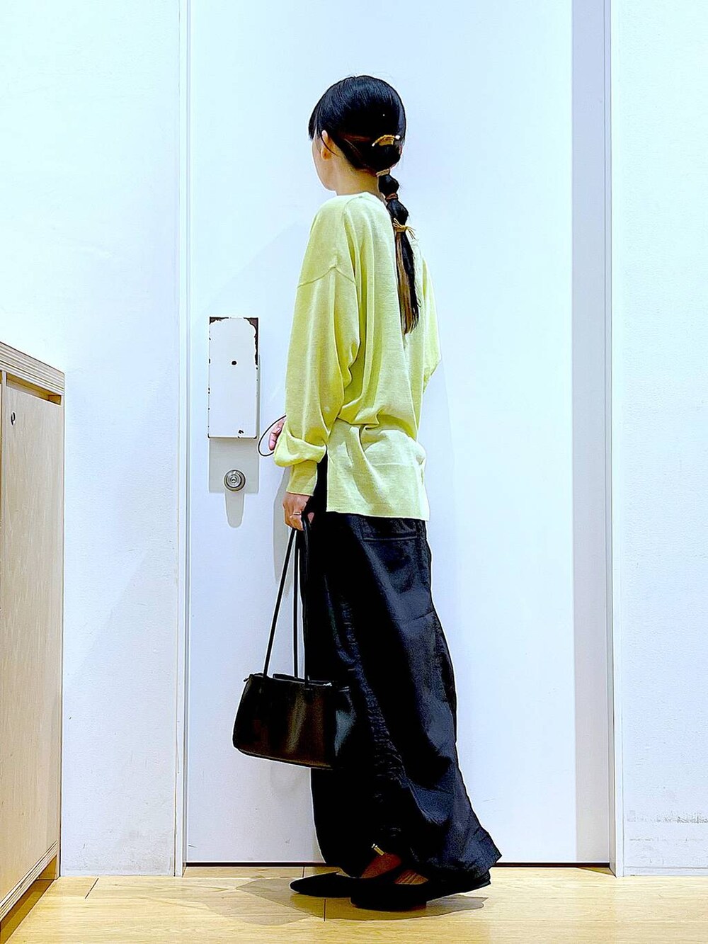 ホワイト系のキャミソール、グリーン系のカーディガン/ボレロ、ブラック系のトートバッグを着用したレディースの春コーディネートの3枚目の写真