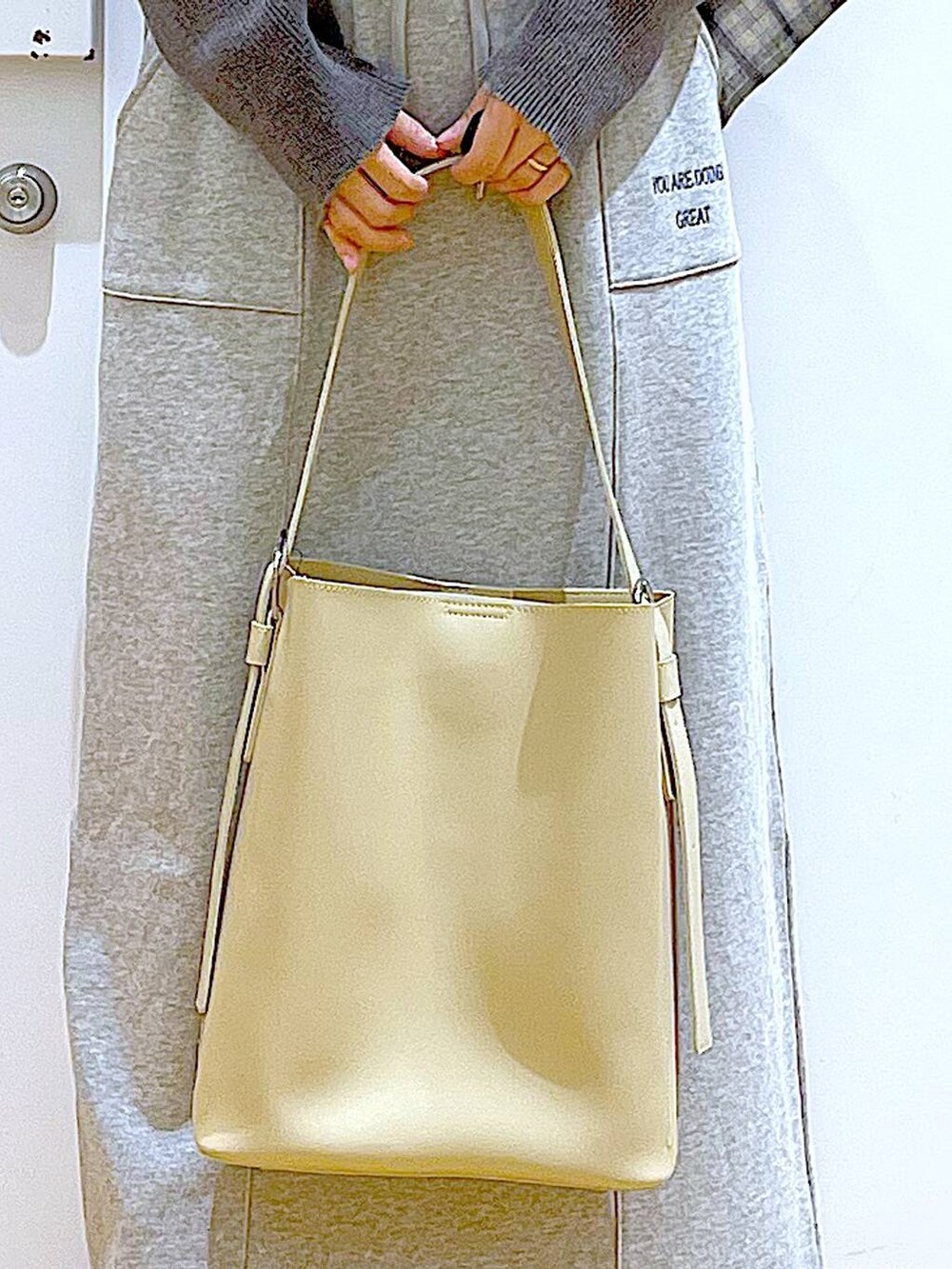 ブラック系のブーツ、ホワイト系のショルダーバッグ、ベージュ系のシャツ/ブラウスを着用したレディースの春コーディネートの9枚目の写真