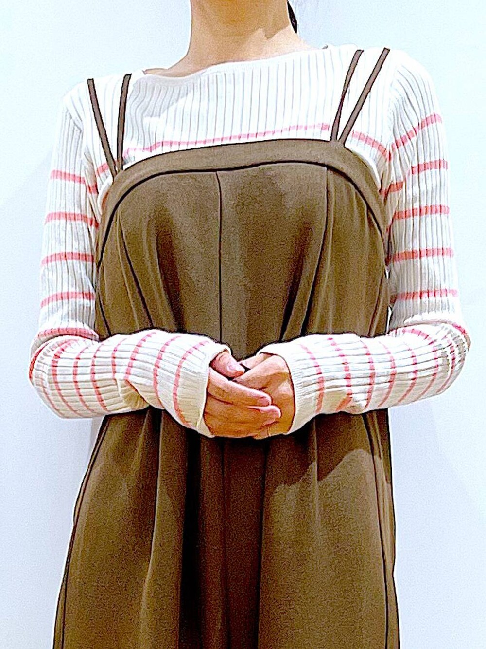 ピンク系のニット/セーター、ブラック系のショルダーバッグ、ベージュ系のブーツを着用したレディースの冬コーディネートの7枚目の写真