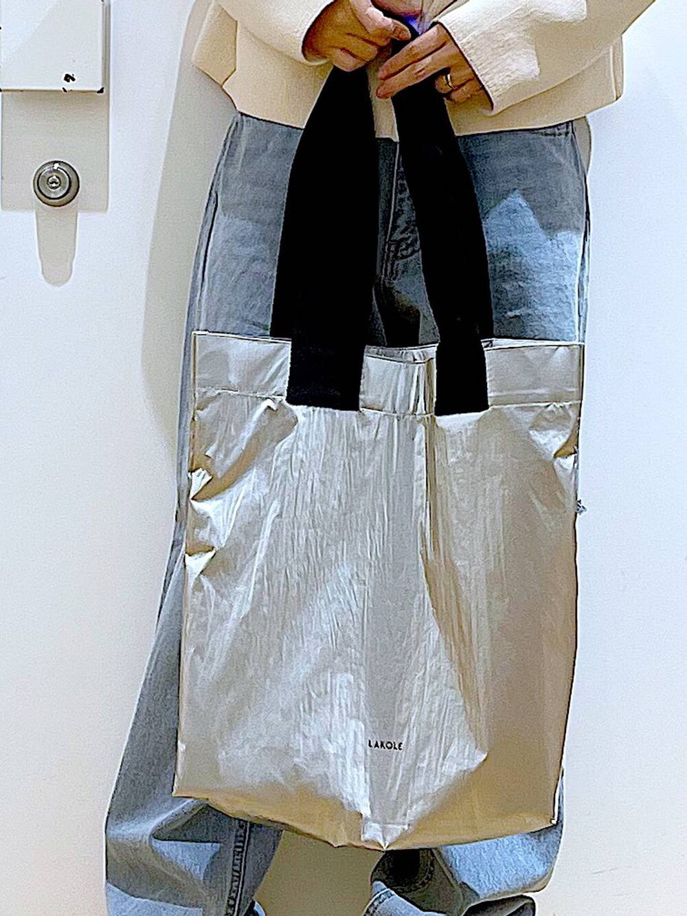 グリーン系のTシャツ/カットソー、ベージュ系のスニーカー、ブルー系のデニムパンツを着用したレディースの冬コーディネートの9枚目の写真