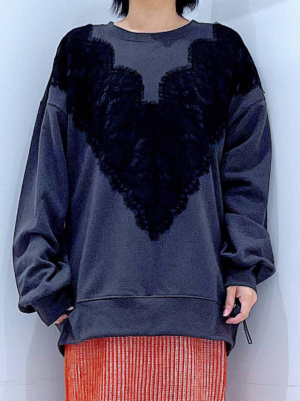 オレンジ系のスカート、ブラック系のブーツ、ブラック系のショルダーバッグを着用したレディースの秋コーディネートの7枚目の写真