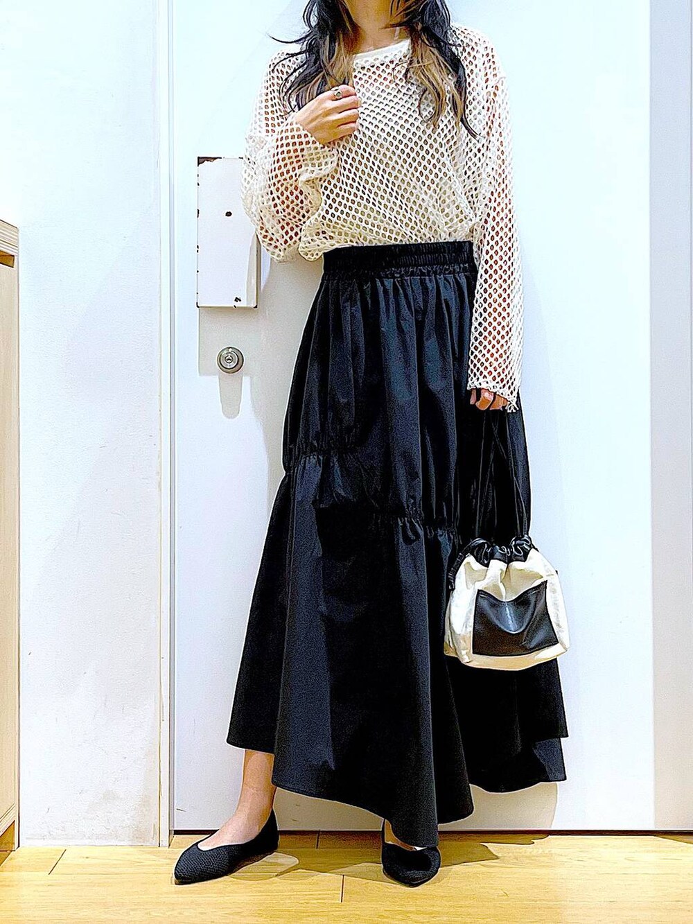 ホワイト系のTシャツ/カットソー、ホワイト系のショルダーバッグ、イエロー系のニット/セーターを着用したレディースの春コーディネートの6枚目の写真