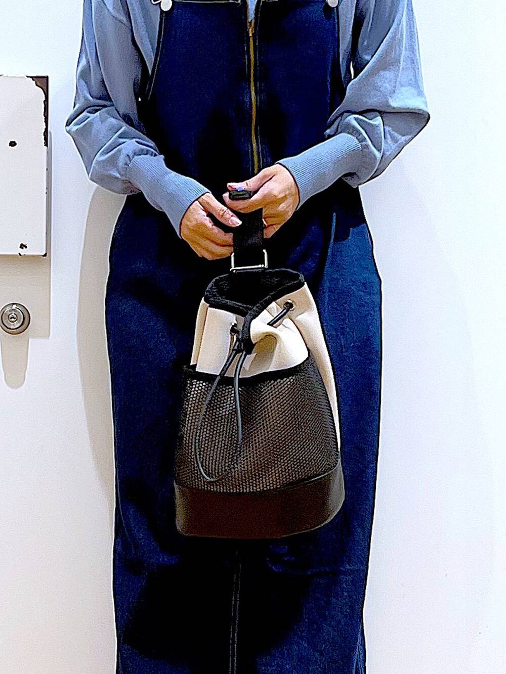 ブルー系のジャンパースカート、ブルー系のカーディガン/ボレロ、ブラック系のブーツを着用したレディースの春コーディネートの9枚目の写真