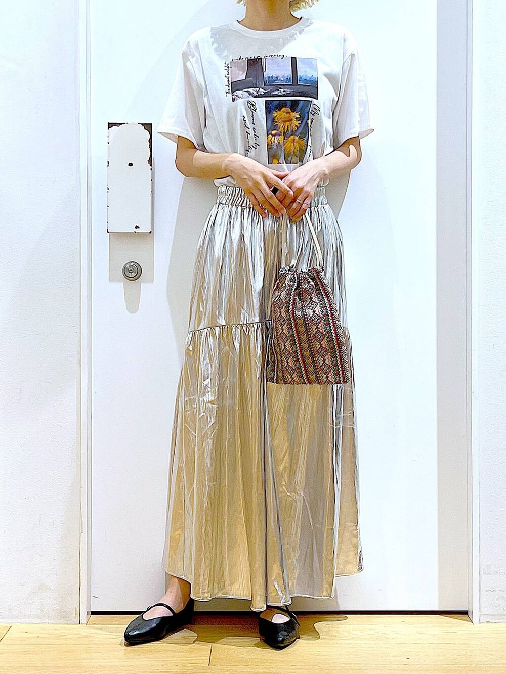 ピンク系のショルダーバッグ、シルバー系のスカート、ホワイト系のTシャツ/カットソーを着用したレディースの夏コーディネートの6枚目の写真