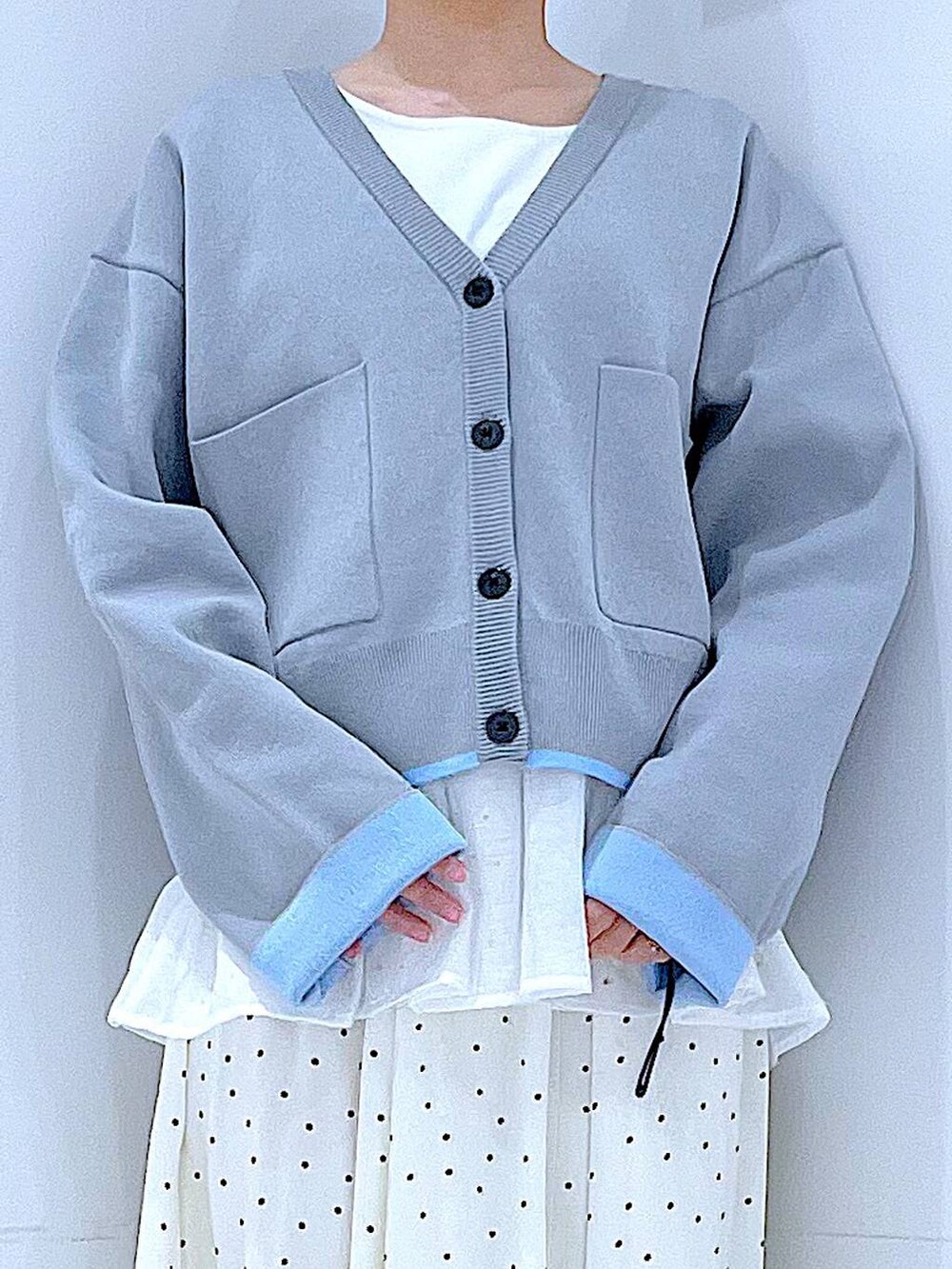 ホワイト系のショルダーバッグ、グレー系のカーディガン/ボレロ、ホワイト系のスカートを着用したレディースの春コーディネートの7枚目の写真