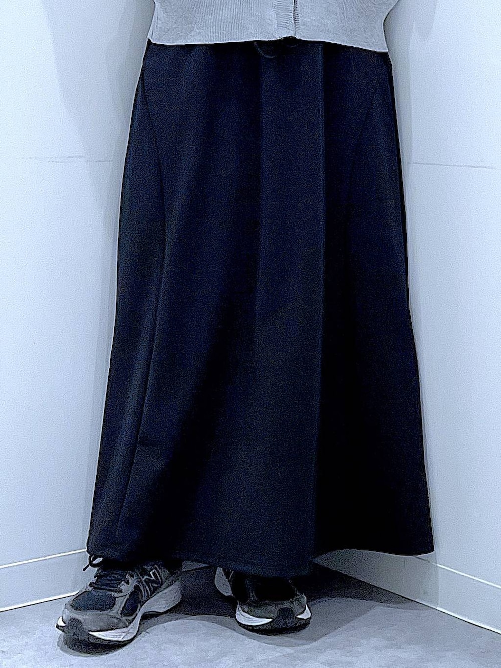 ホワイト系のショルダーバッグ、ブラック系のスカート、グレー系のカーディガン/ボレロを着用したレディースの春コーディネートの8枚目の写真