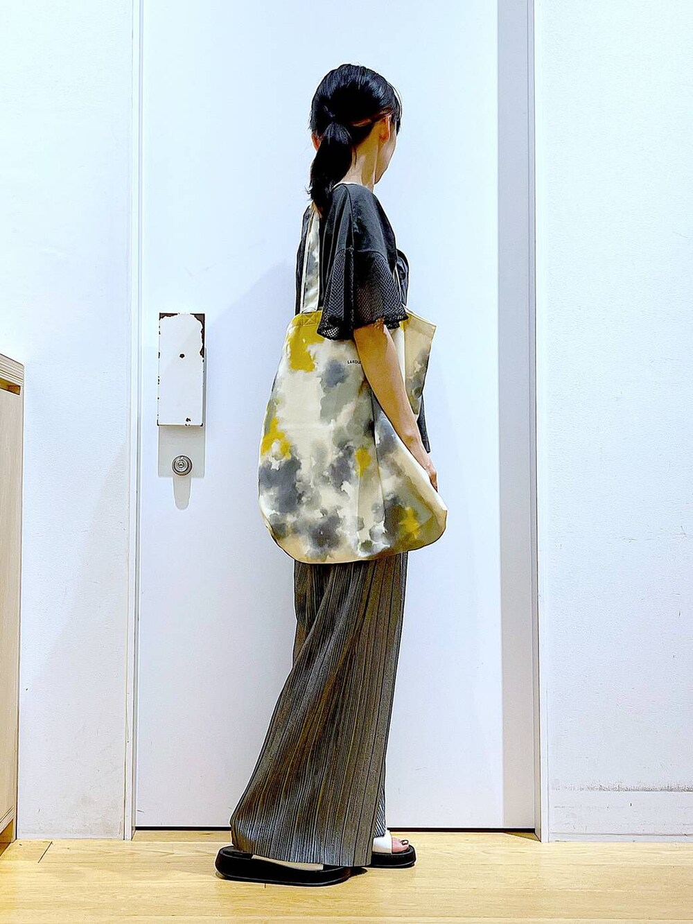 ホワイト系のサンダル、イエロー系のトートバッグ、グレー系のその他パンツを着用したレディースの秋コーディネートの4枚目の写真