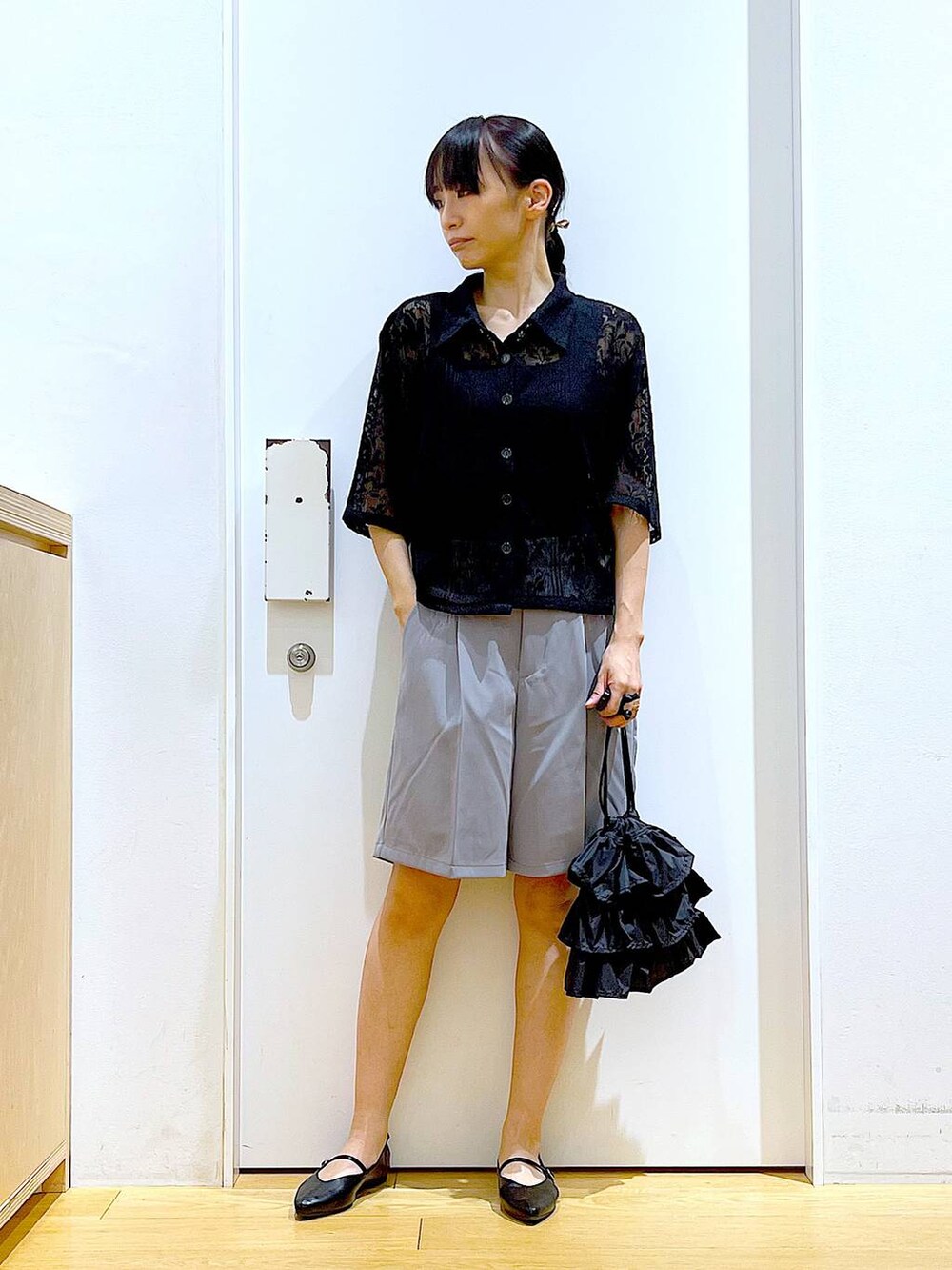 ブラック系のショルダーバッグ、ブラック系のパンプス、グレー系のその他パンツを着用したレディースの夏コーディネートの2枚目の写真