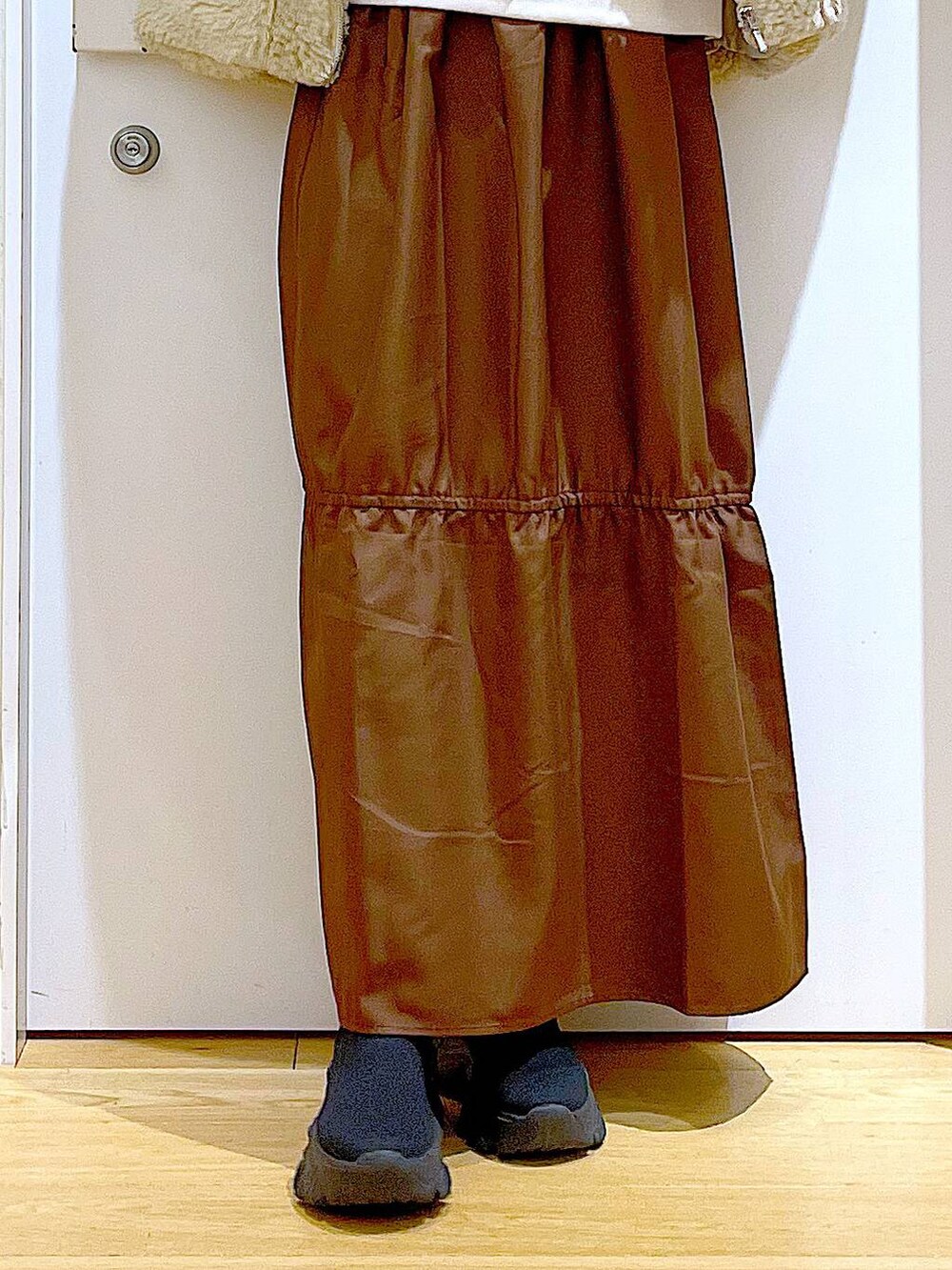 ホワイト系のブルゾン、ホワイト系のスウェット、ブラック系のブーツを着用したレディースの冬コーディネートの8枚目の写真