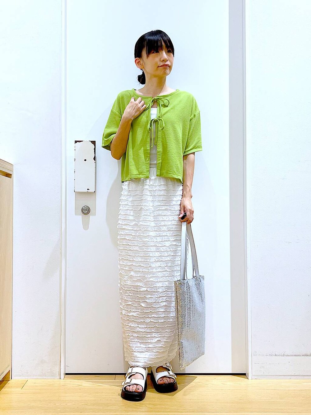 ホワイト系のサンダル、シルバー系のトートバッグ、ホワイト系のスカートを着用したレディースの秋コーディネートの2枚目の写真