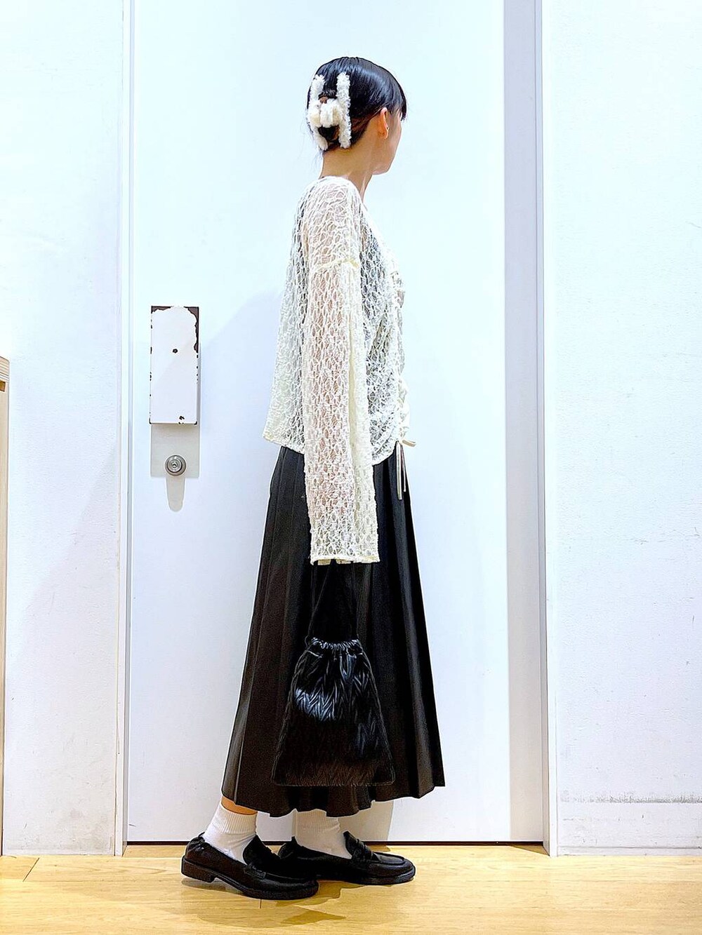 ブラック系のショルダーバッグ、ブラック系のローファー、ベージュ系のTシャツ/カットソーを着用したレディースの秋コーディネートの4枚目の写真