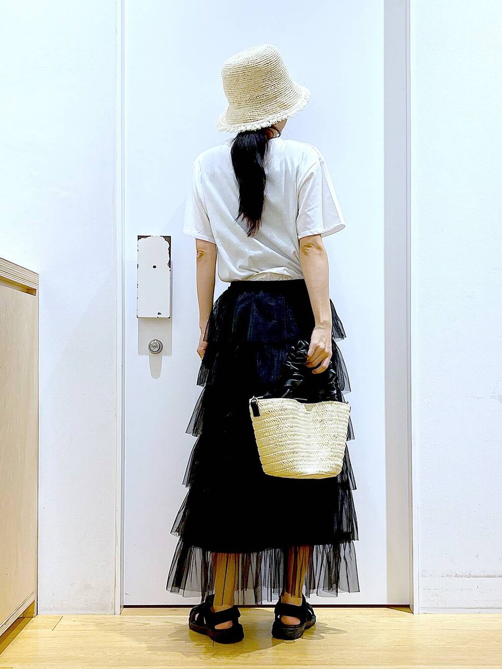 ホワイト系のショルダーバッグ、ブラック系のスリッポン、ブラック系のスカートを着用したレディースの夏コーディネートの5枚目の写真