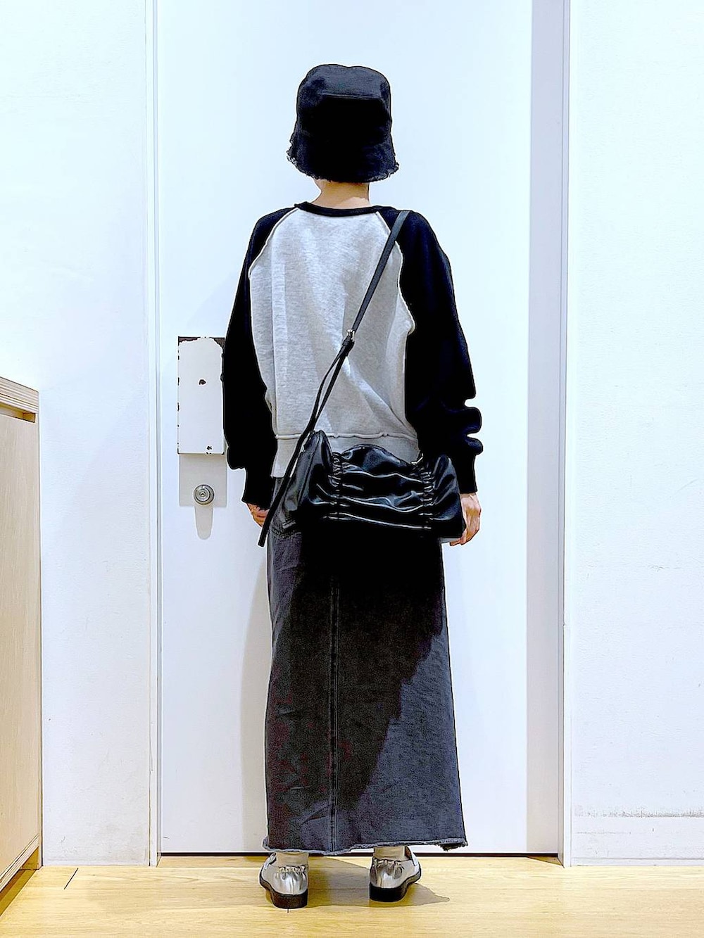 シルバー系のローファー、ブラック系のニット/セーター、ブラック系のショルダーバッグを着用したレディースの冬コーディネートの5枚目の写真