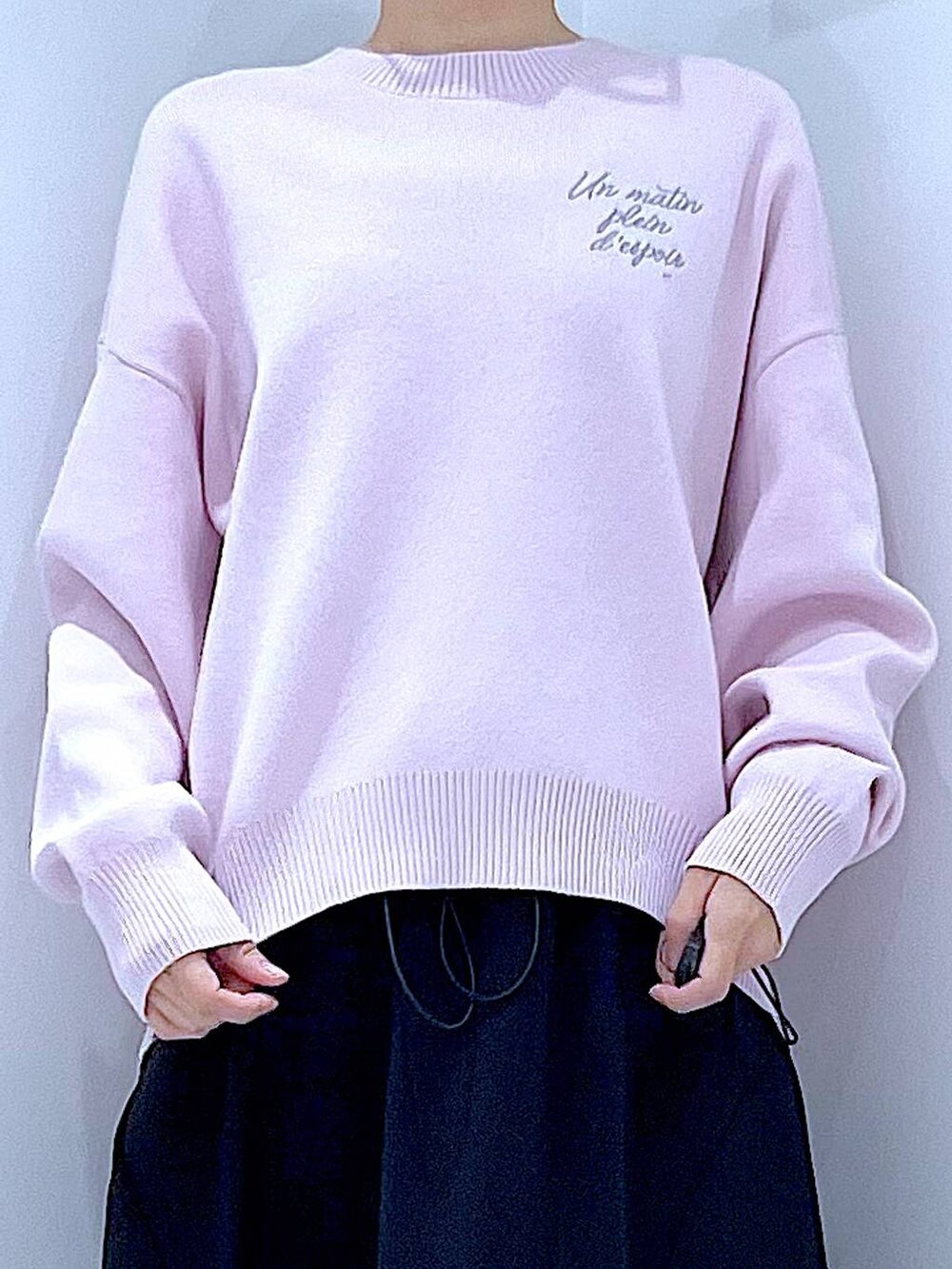 ピンク系のニット/セーター、ブラック系のショルダーバッグ、ブラック系のスカートを着用したレディースの春コーディネートの7枚目の写真