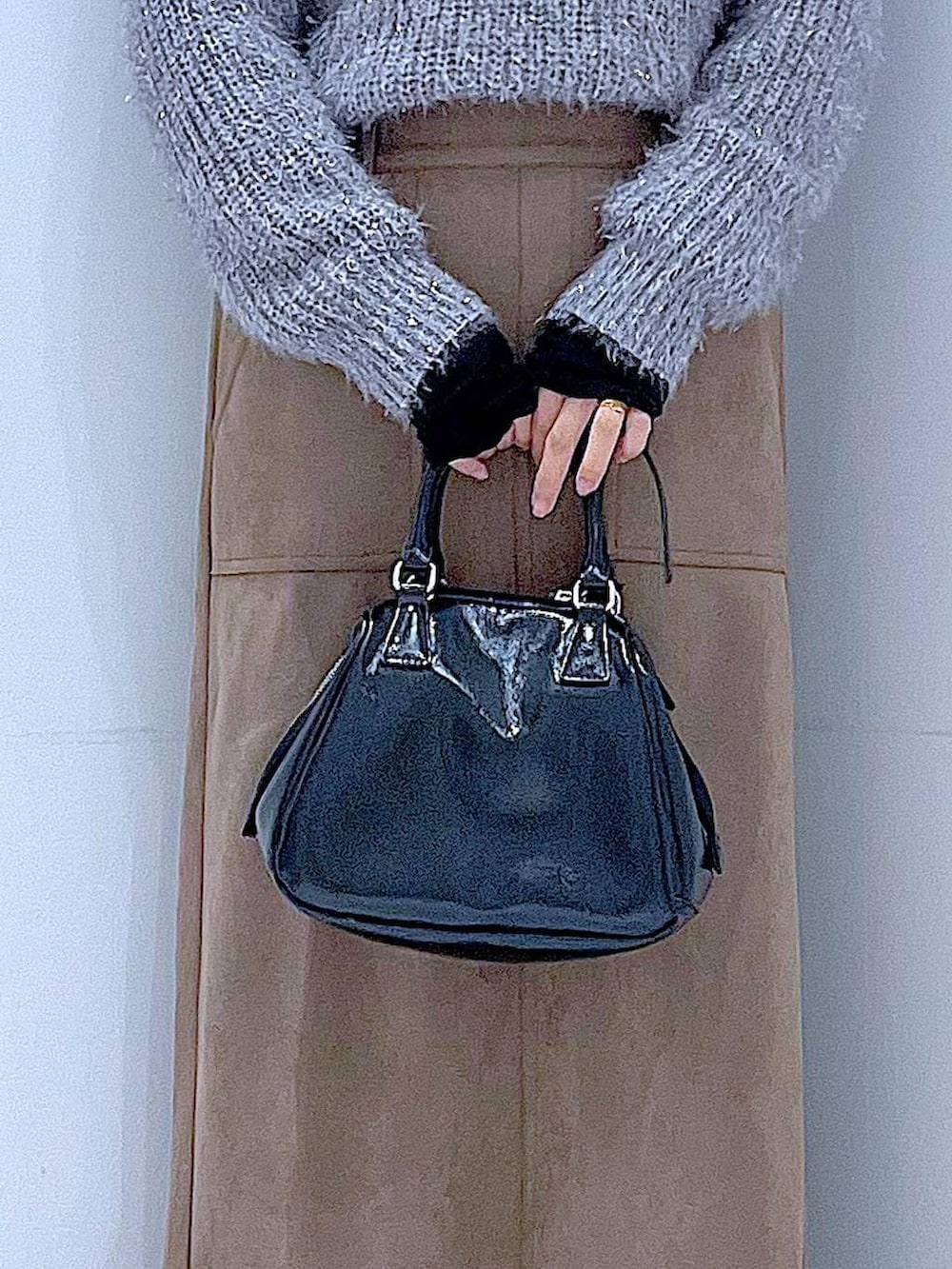 ブラック系のブーツ、ブラック系のショルダーバッグ、ブラウン系のスカートを着用したレディースの冬コーディネートの9枚目の写真