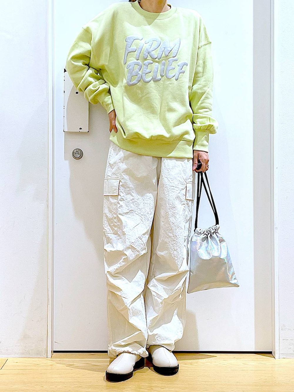 イエロー系のスウェット、ベージュ系のブーツ、その他のショルダーバッグを着用したレディースの春コーディネートの6枚目の写真