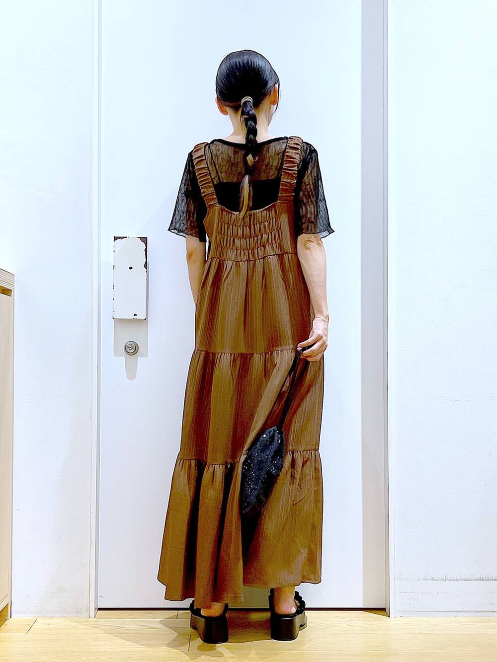 ブラック系のサンダル、ブラック系のショルダーバッグ、ベージュ系のワンピースを着用したレディースの夏コーディネートの5枚目の写真