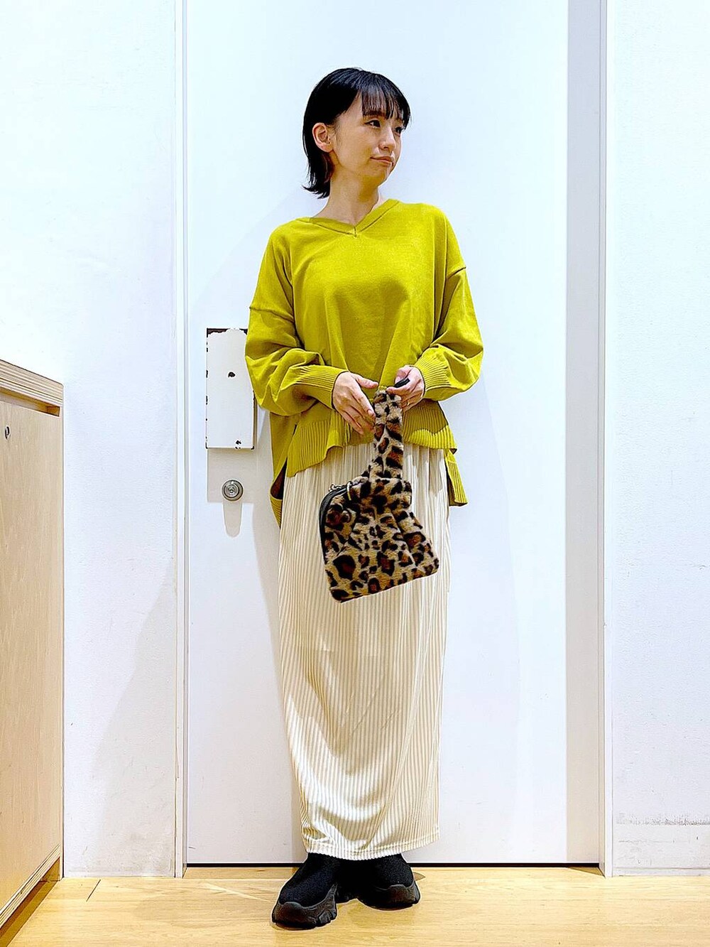 その他のショルダーバッグ、ホワイト系のスカート、ブラック系のブーツを着用したレディースの冬コーディネートの2枚目の写真