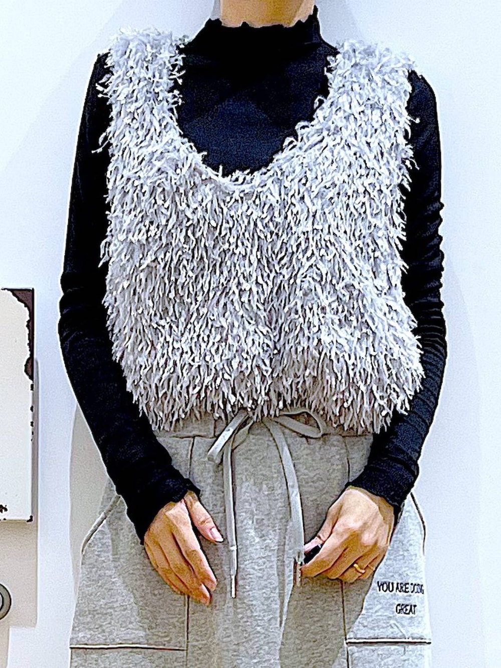 ブラック系のブーツ、ブラック系のTシャツ/カットソー、グレー系のスカートを着用したレディースの春コーディネートの7枚目の写真