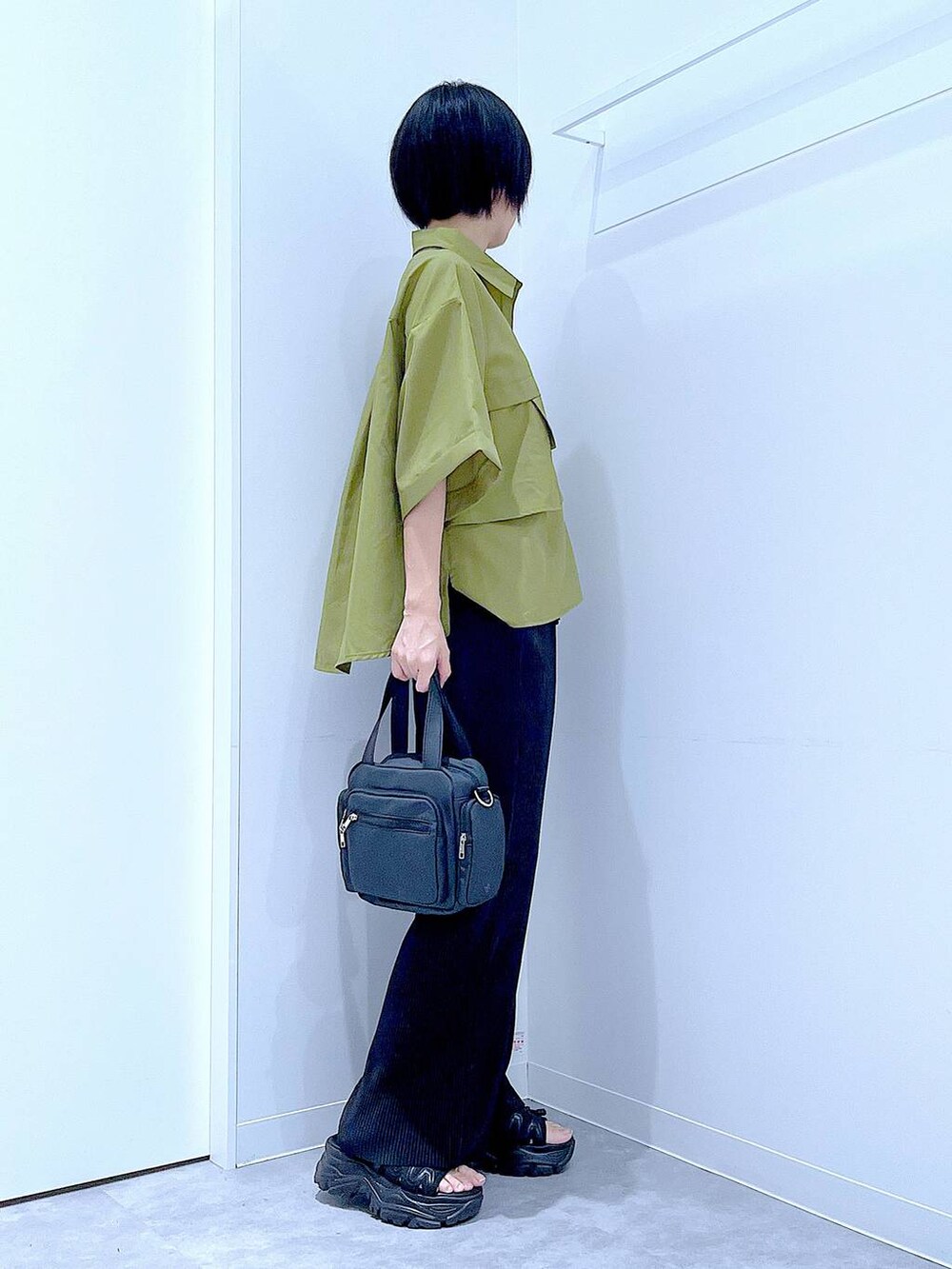 ブラック系のスニーカー、ブラック系のショルダーバッグ、グリーン系のシャツ/ブラウスを着用したレディースの夏コーディネートの4枚目の写真