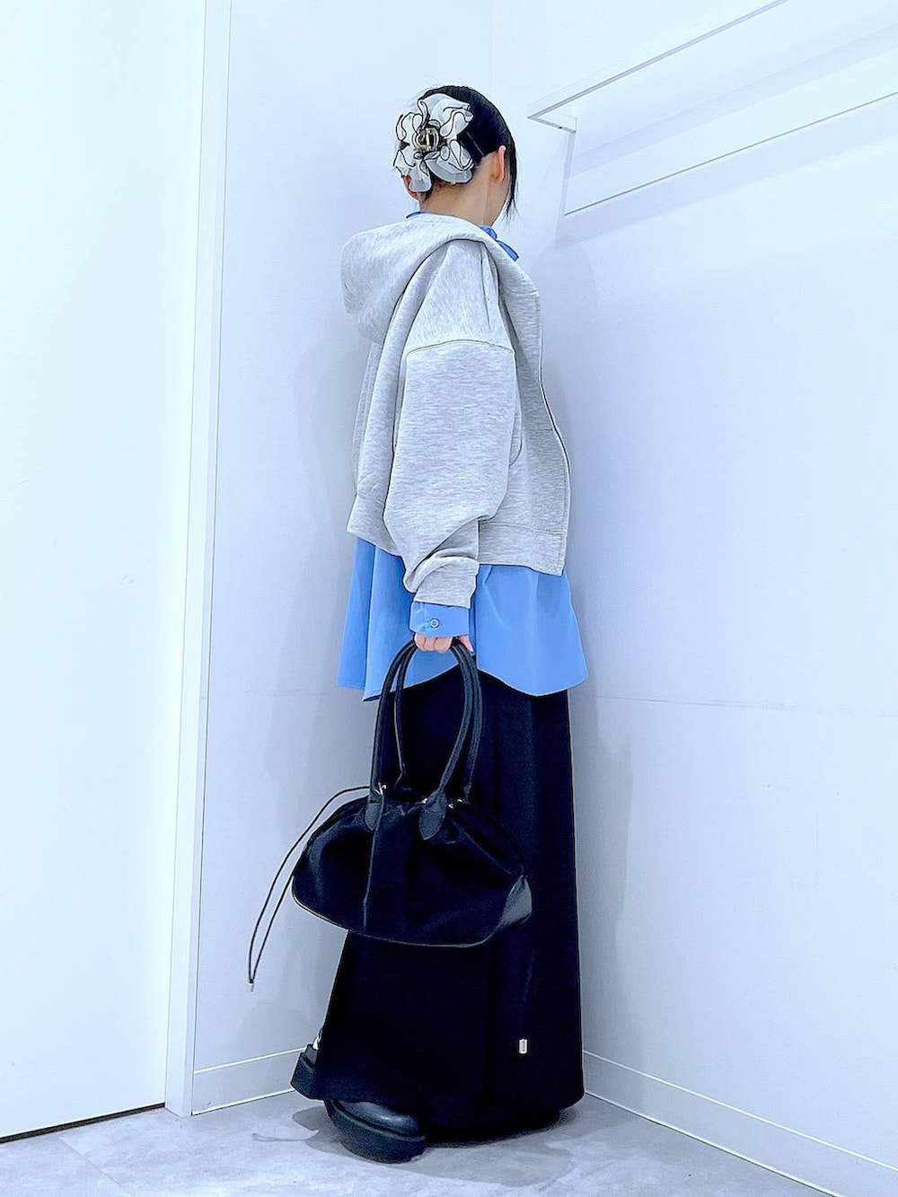 ブラック系のハンドバッグ、ブラック系のスカート、ブラック系のサンダルを着用したレディースの冬コーディネートの4枚目の写真