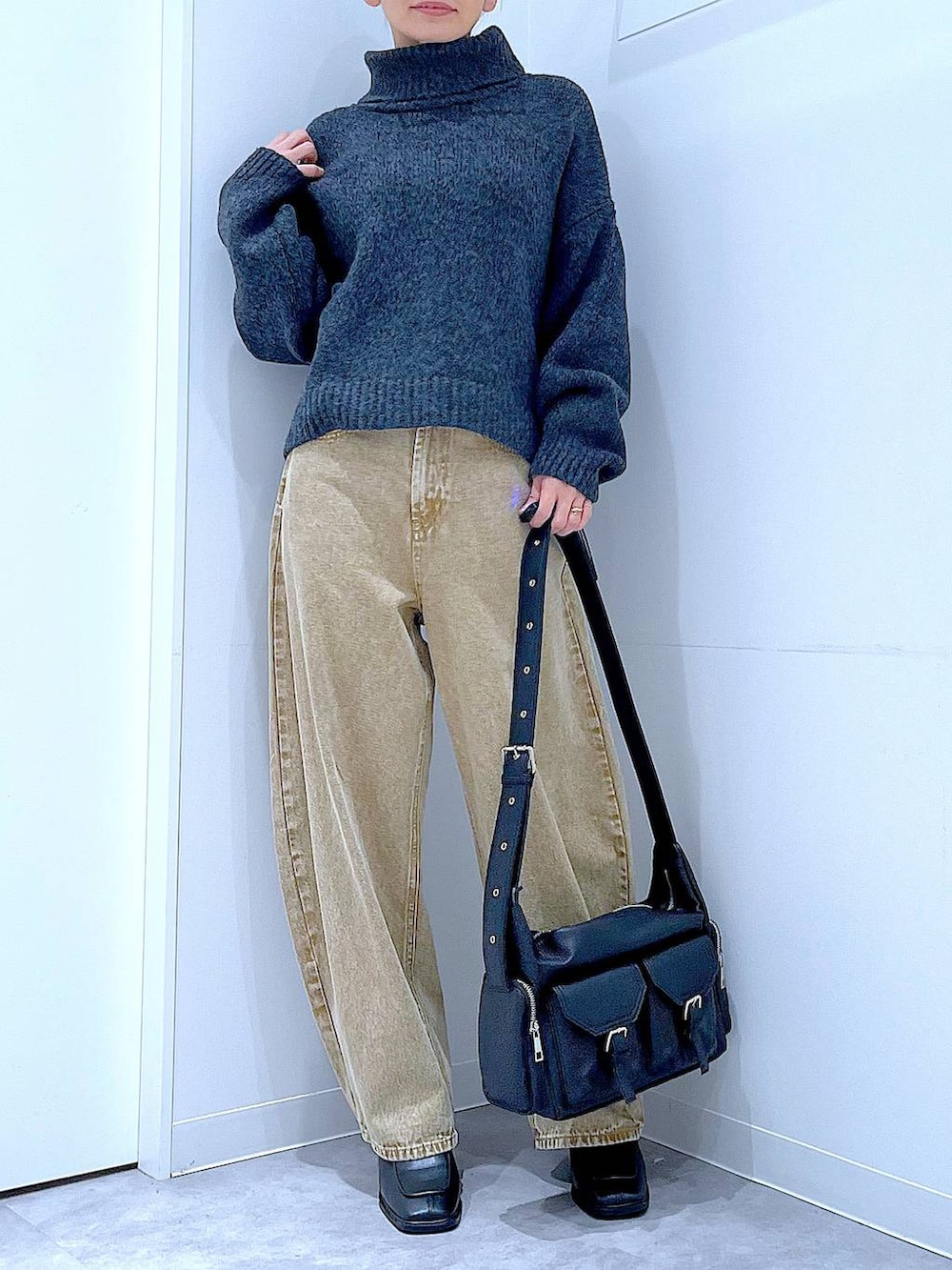 ベージュ系のデニムパンツ、ブラック系のブーツ、グレー系のニット/セーターを着用したレディースの冬コーディネートの6枚目の写真