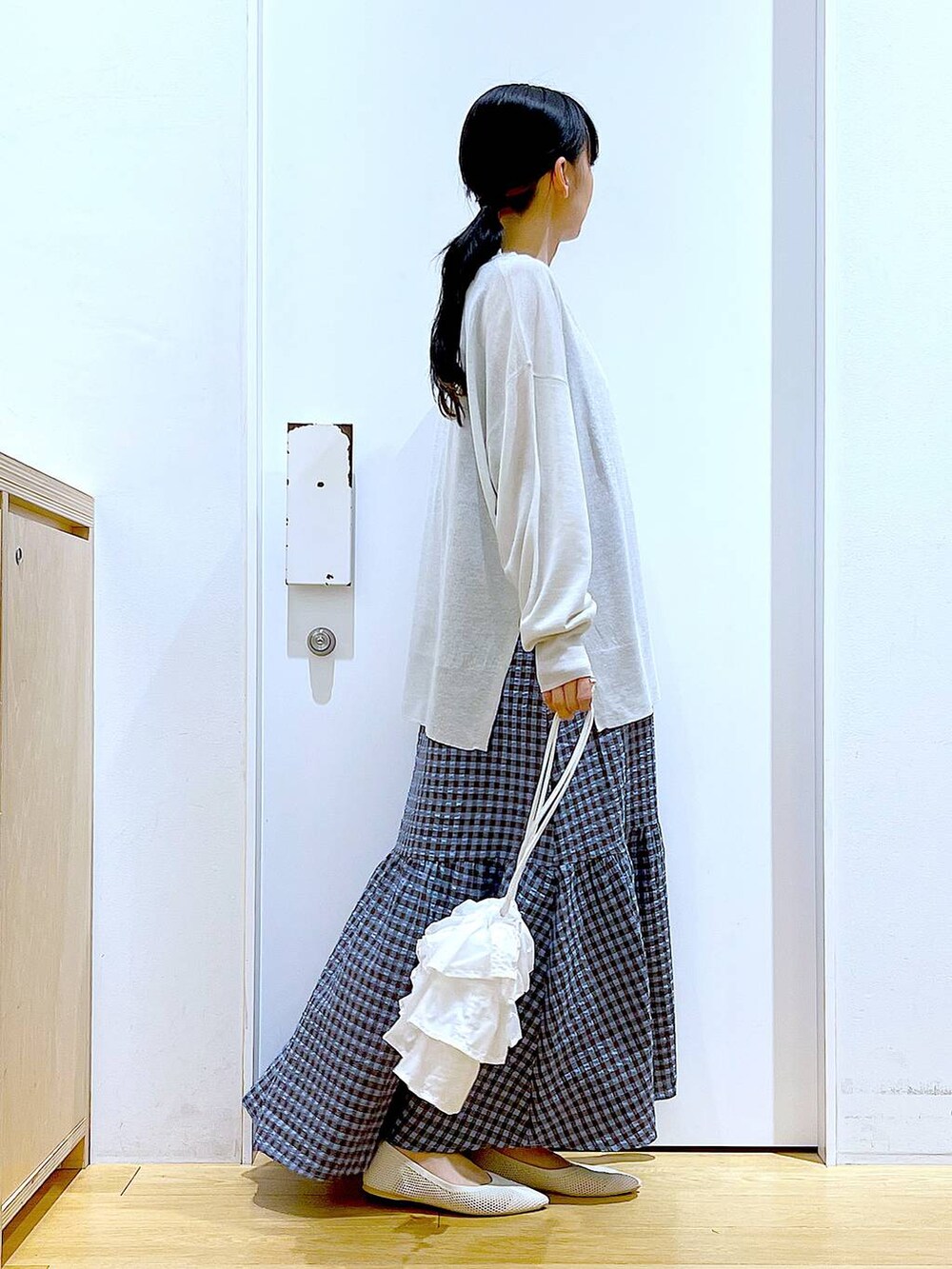 ホワイト系のショルダーバッグ、ブルー系のワンピース、ホワイト系のパンプスを着用したレディースの春コーディネートの4枚目の写真