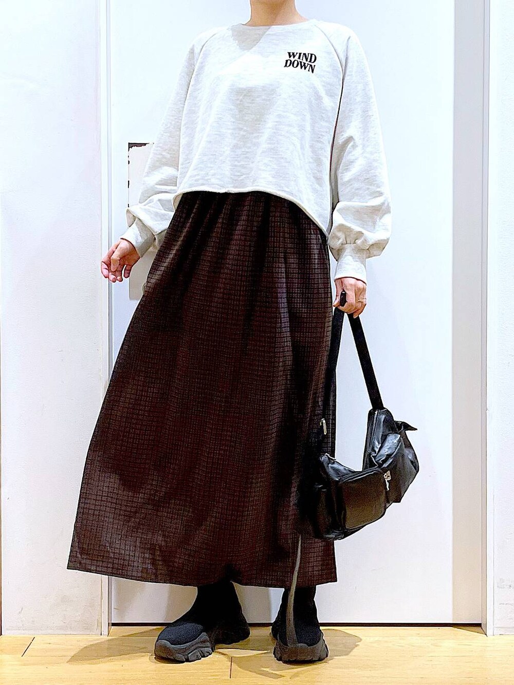 ブラック系のブーツ、ブラック系のショルダーバッグ、ブラウン系のワンピースを着用したレディースの冬コーディネートの6枚目の写真