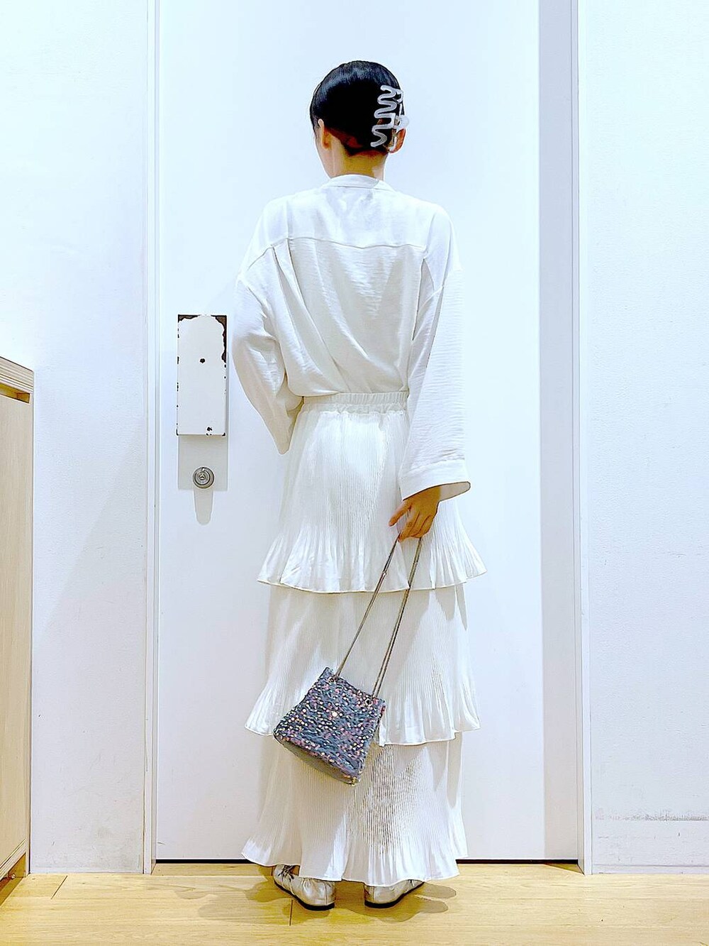 ベージュ系のスカート、シルバー系のパンプス、ホワイト系のシャツ/ブラウスを着用したレディースの秋コーディネートの5枚目の写真