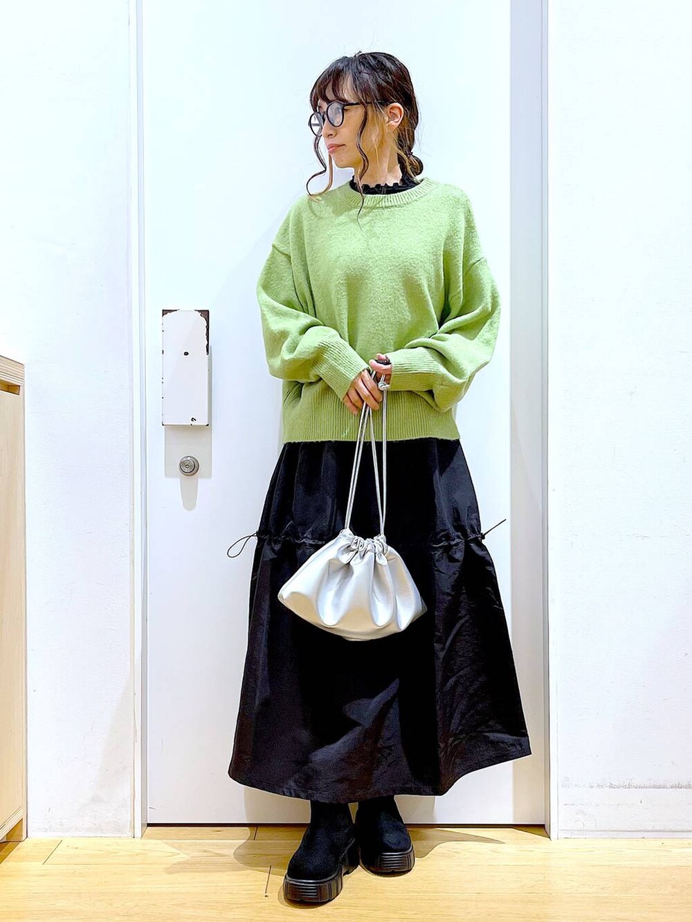 ブラック系のTシャツ/カットソー、シルバー系のショルダーバッグ、ブラック系のブーツを着用したレディースの冬コーディネートの2枚目の写真