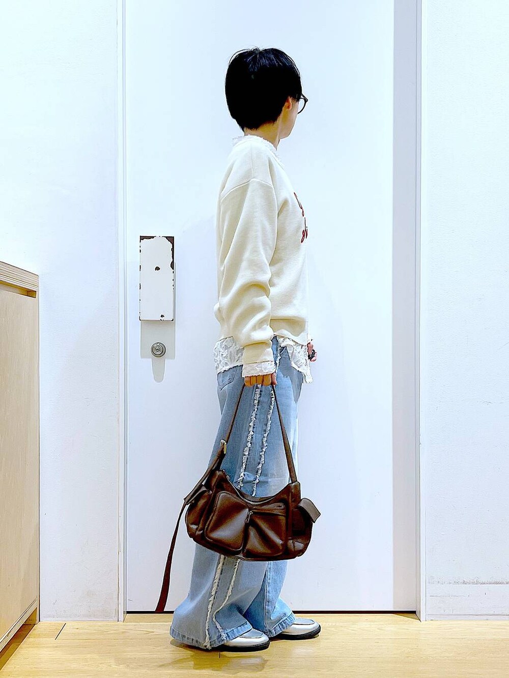 シルバー系のローファー、ブラウン系のショルダーバッグ、ホワイト系のニット/セーターを着用したレディースの春コーディネートの4枚目の写真