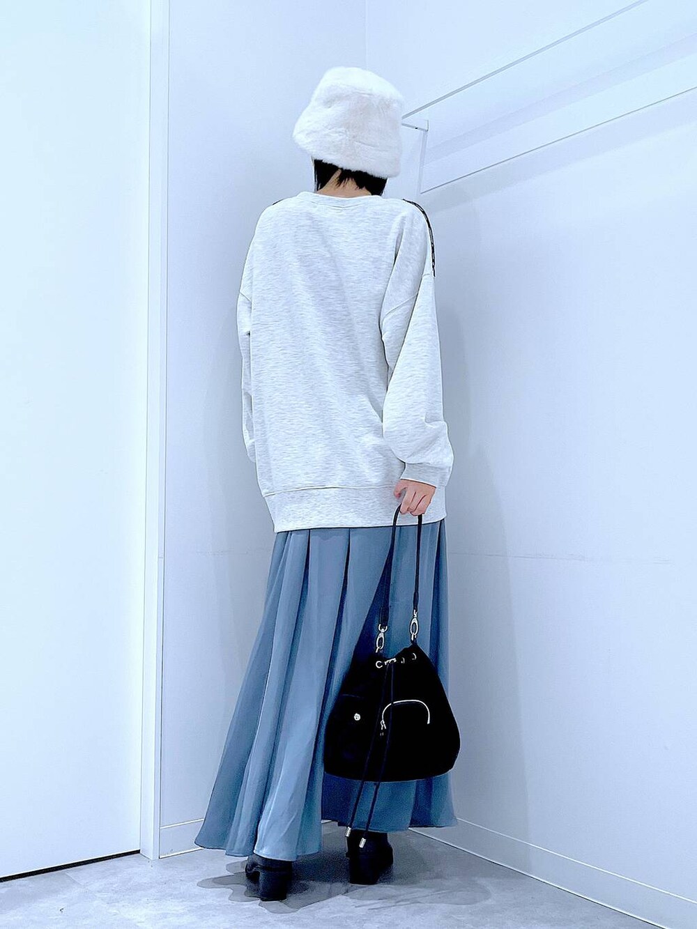 ブラック系のショルダーバッグ、ブラック系のブーツ、ベージュ系のスウェットを着用したレディースの冬コーディネートの5枚目の写真